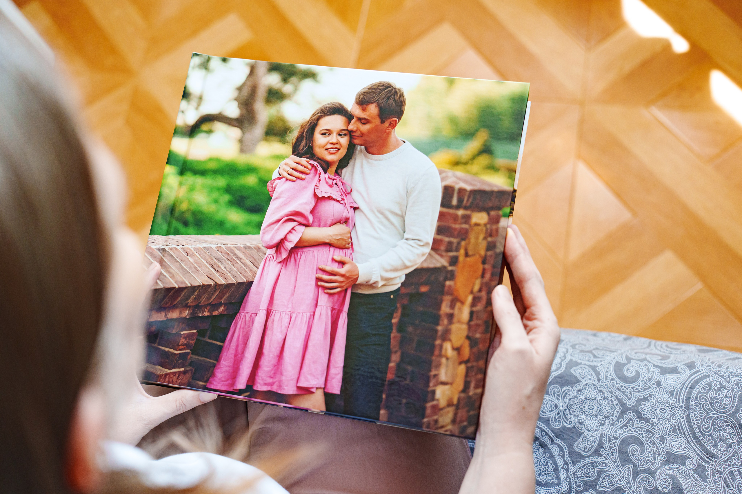 Готовая фотокнига о беременности в Олд Хаус | Девушка держит книгу с обложкой-объятиями родителей | Фотограф Андрей Сайфутдинов Ростов-на-Дону