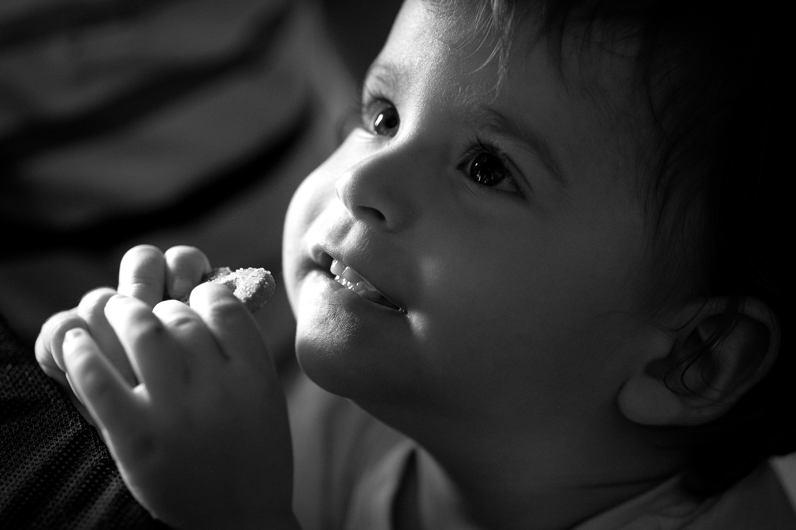 Фотография счастливого ребёнка, кушающего печенье 