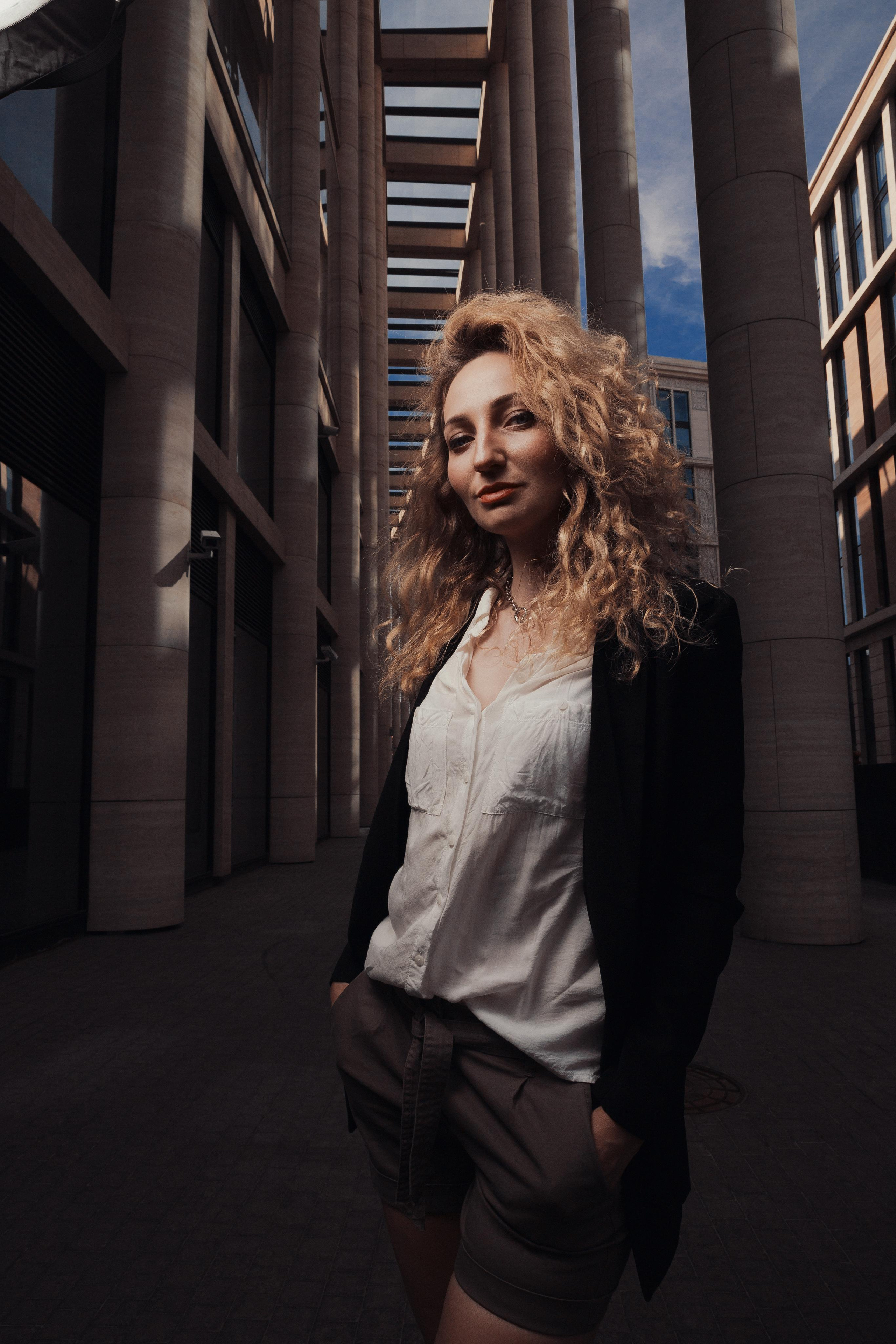 flash photo of a girl in front of a modern building