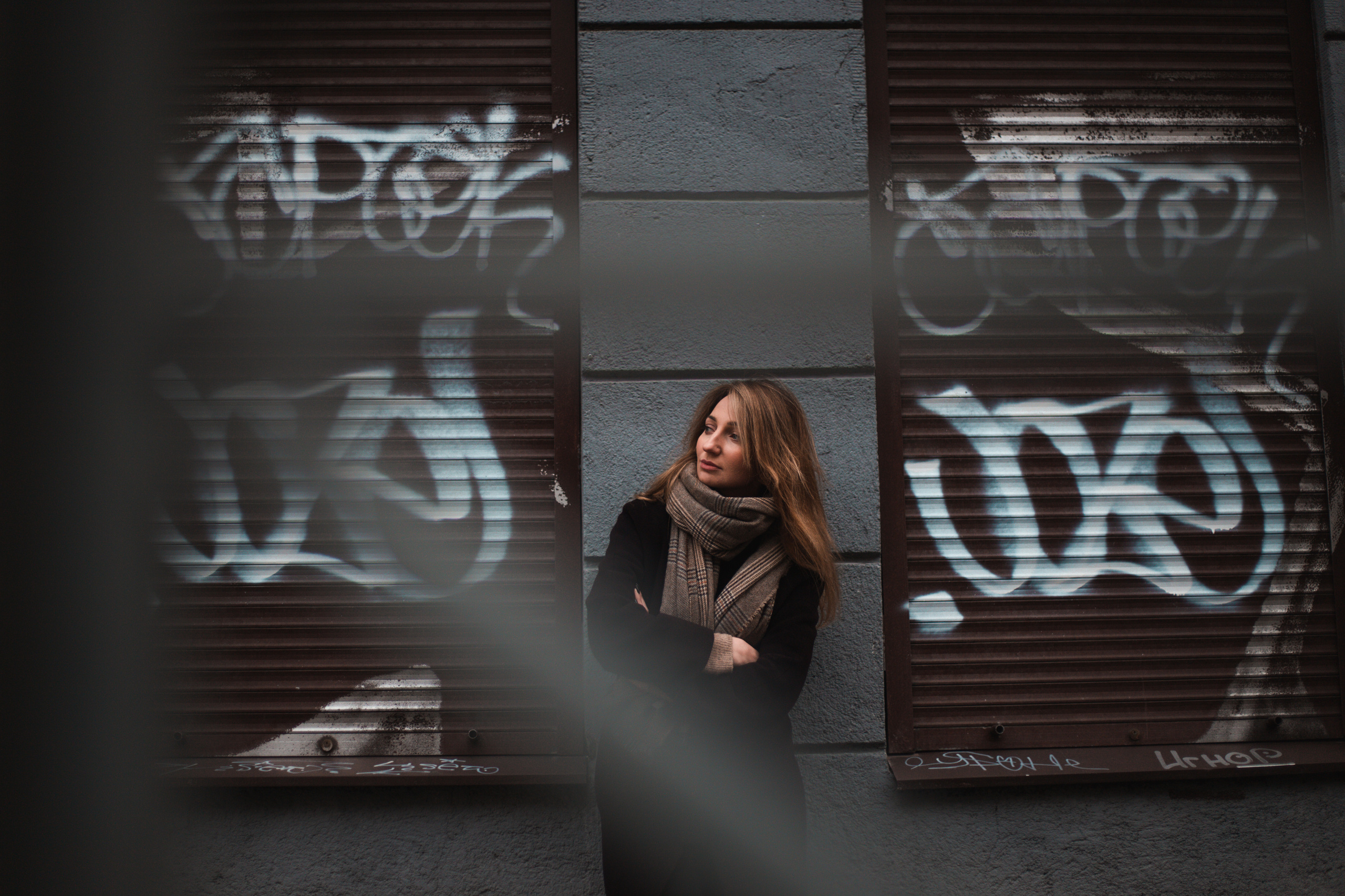 urban photo of a girl against a graffiti-covered wall