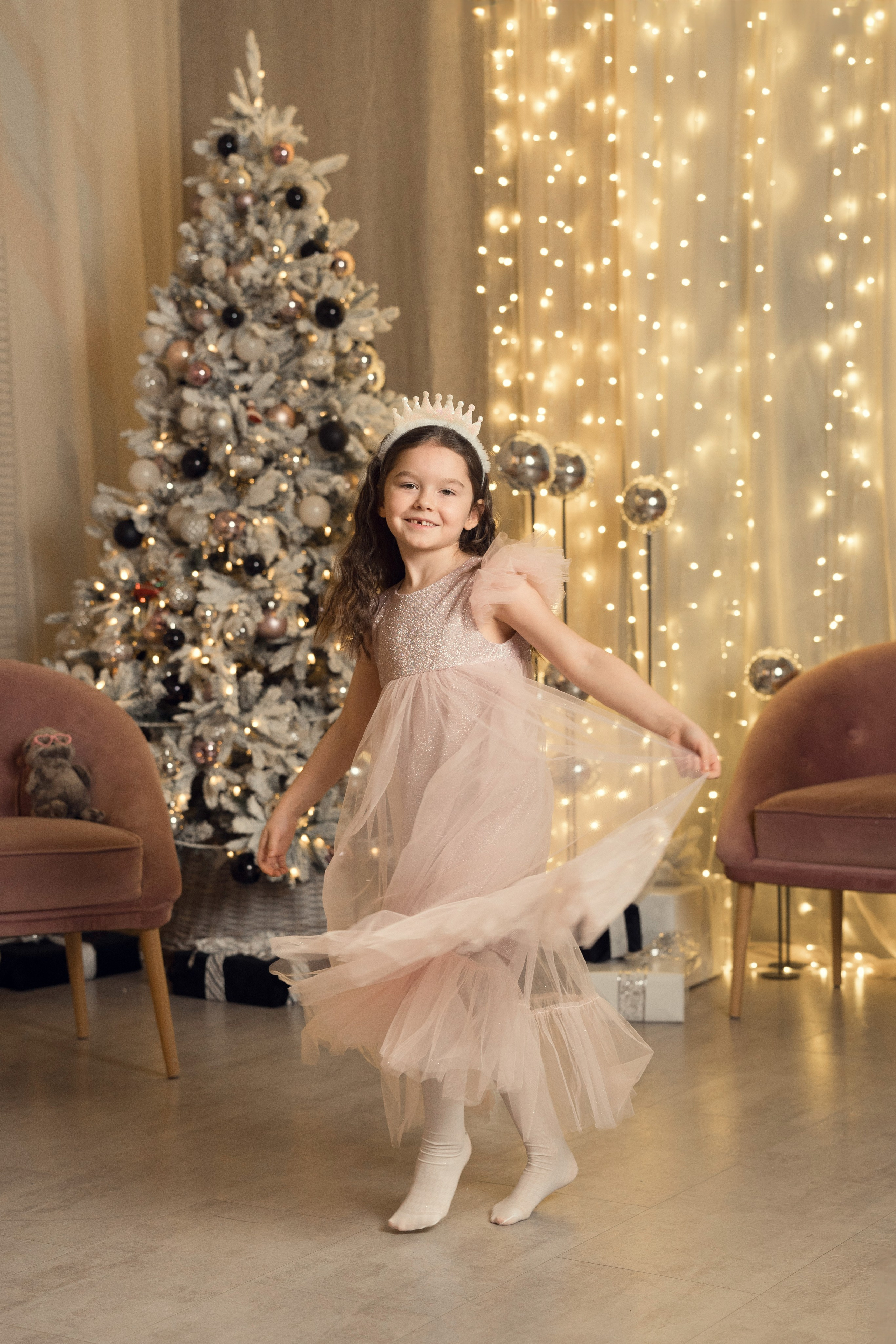 Новогодняя фотосессии девочки в студии, где она кружится под музыку.