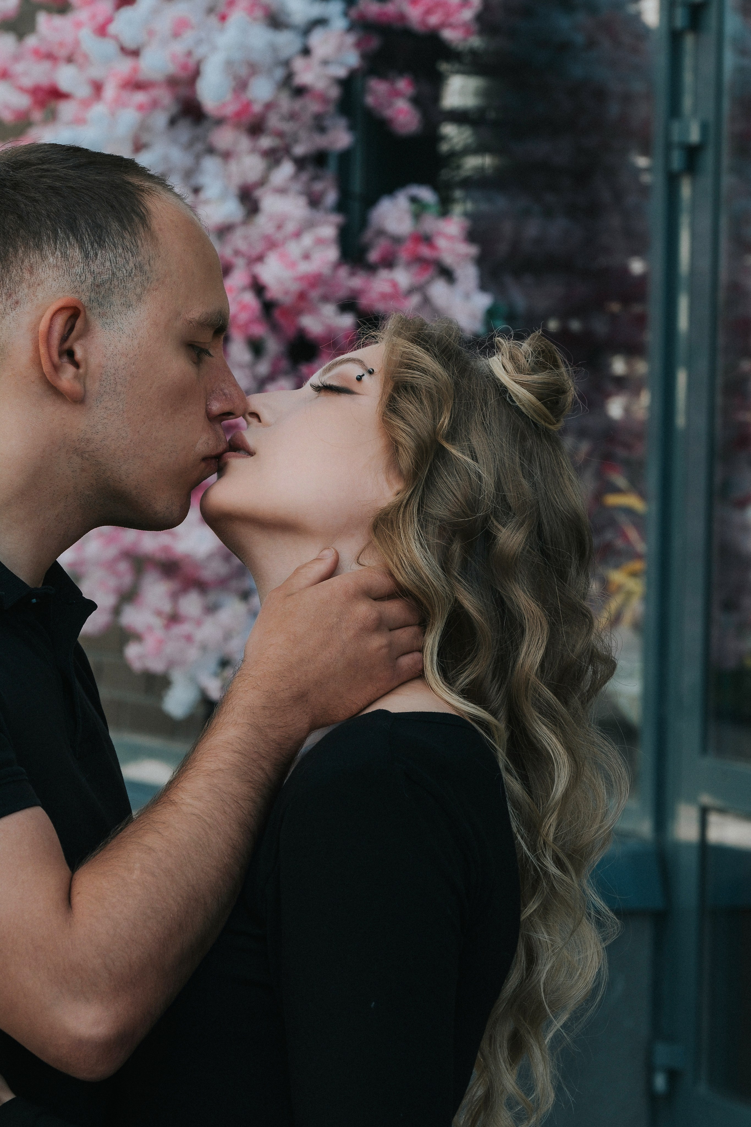 Молодая пара мужчина и девушка дурачатся в городских локациях в черных футболках и синих джинсах, лав стори для влюбленной пары на кануне свадьбы