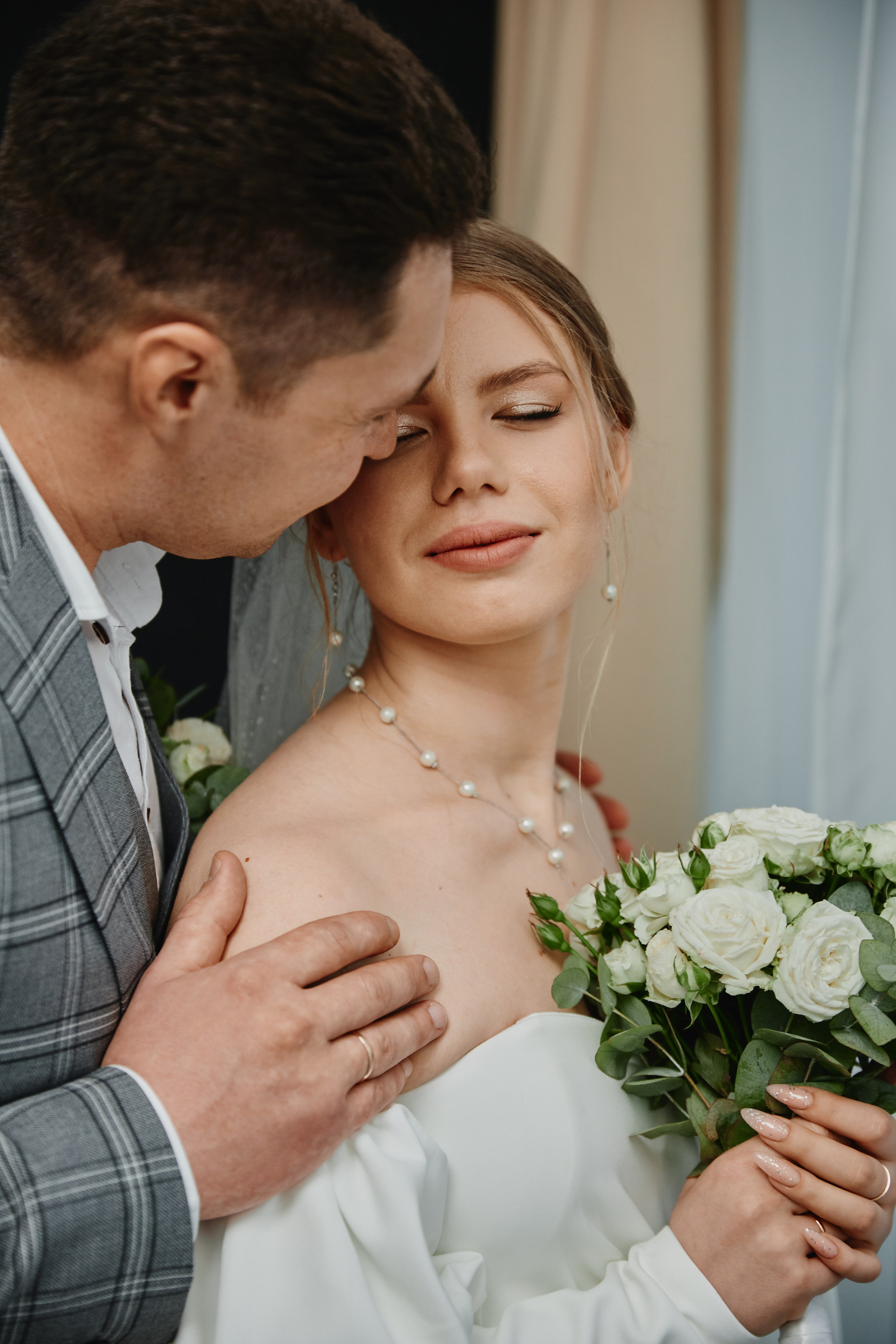 Жених обнимает невесту за плечи в фотостудии Анапы