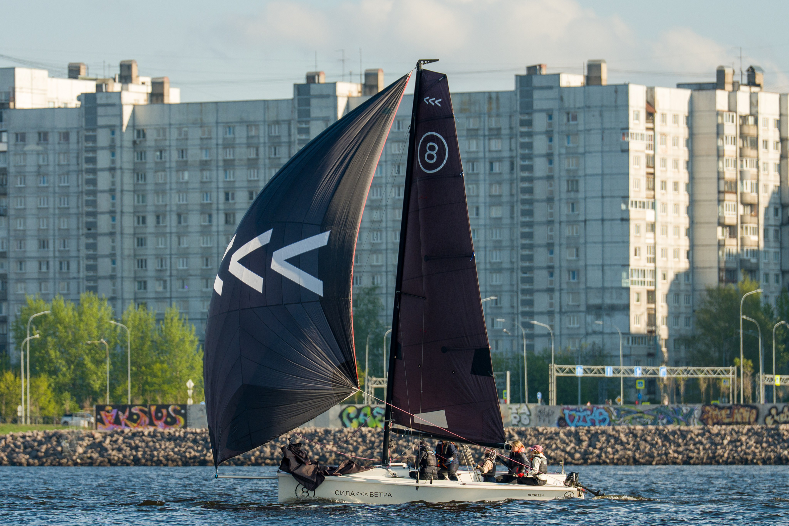 SV20 crew powers under a gennaker, city waterfront behind them