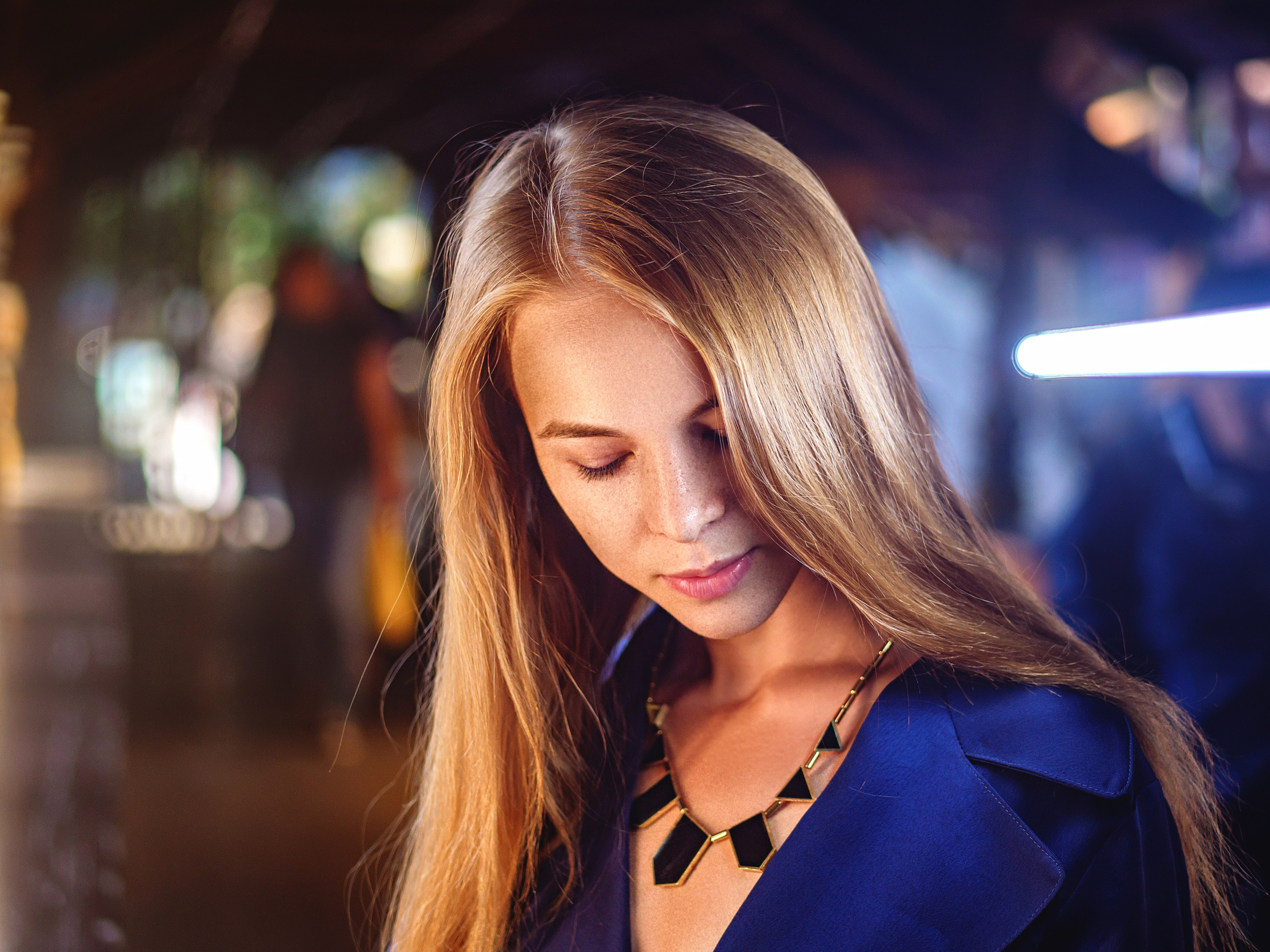 очаровательная блондинка в смешанном желто синем свете на улице в арке.