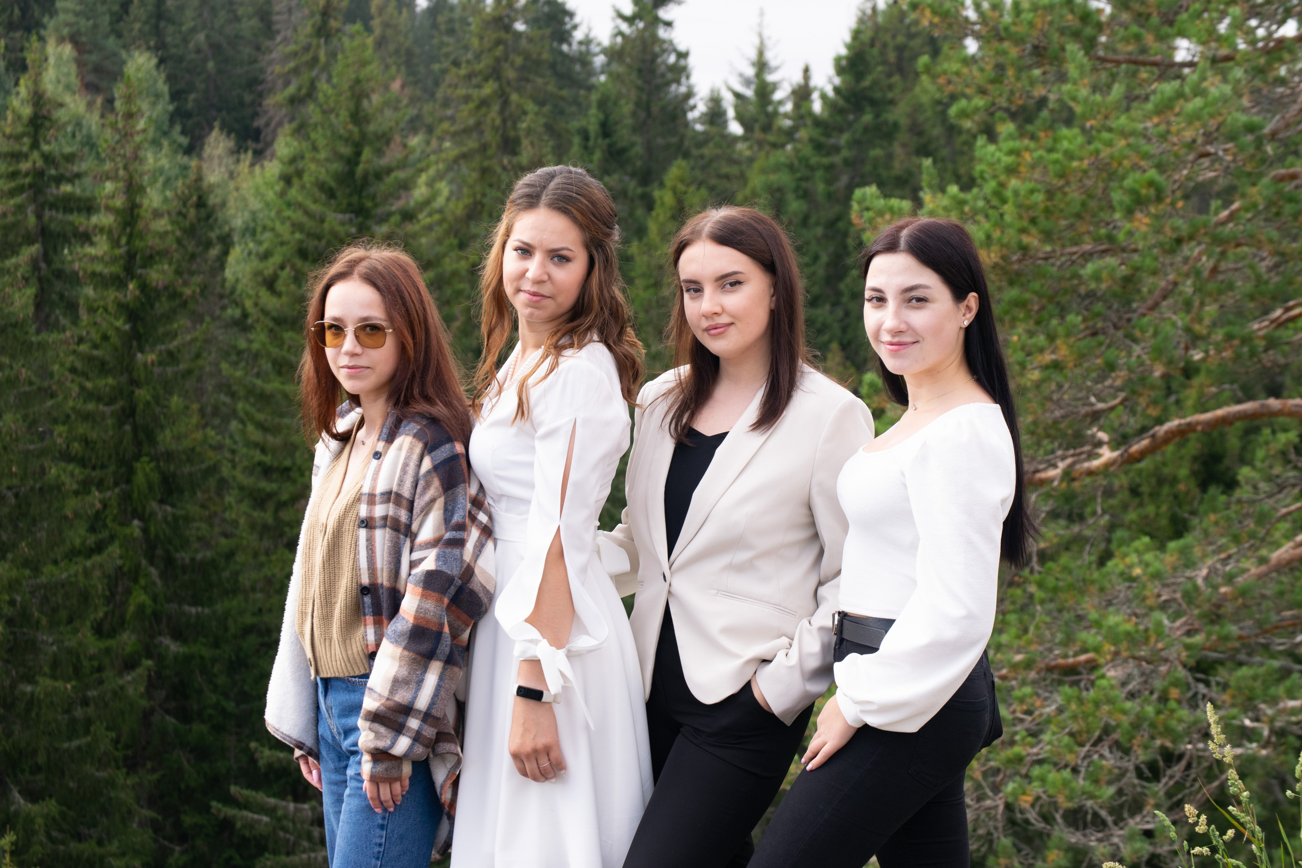 Свадебная фотосъемка на горе Паасо Сортавальский район. Невеста с подружками стоит на фоне леса.