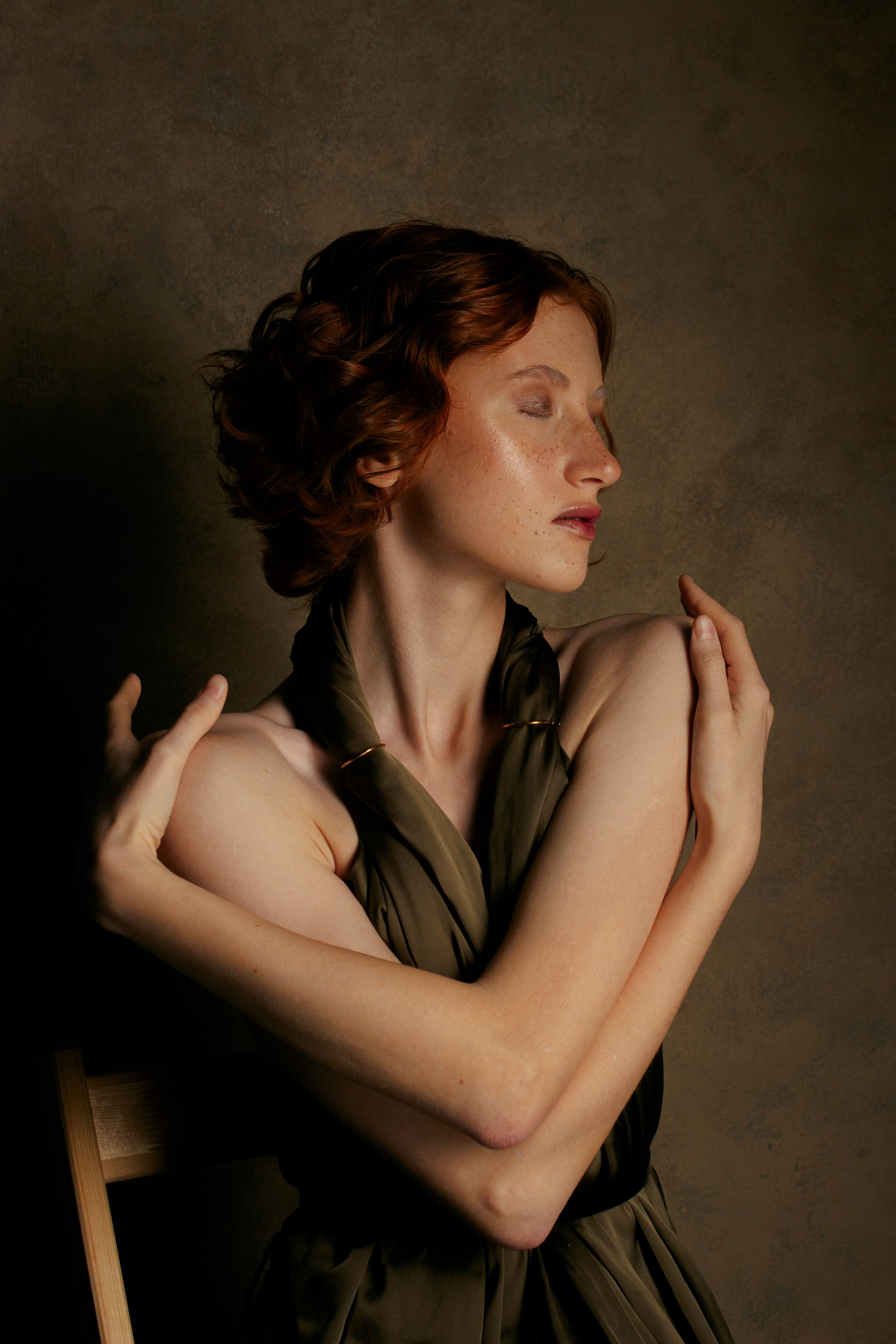 рыжая девушка обнимает себя за плечи