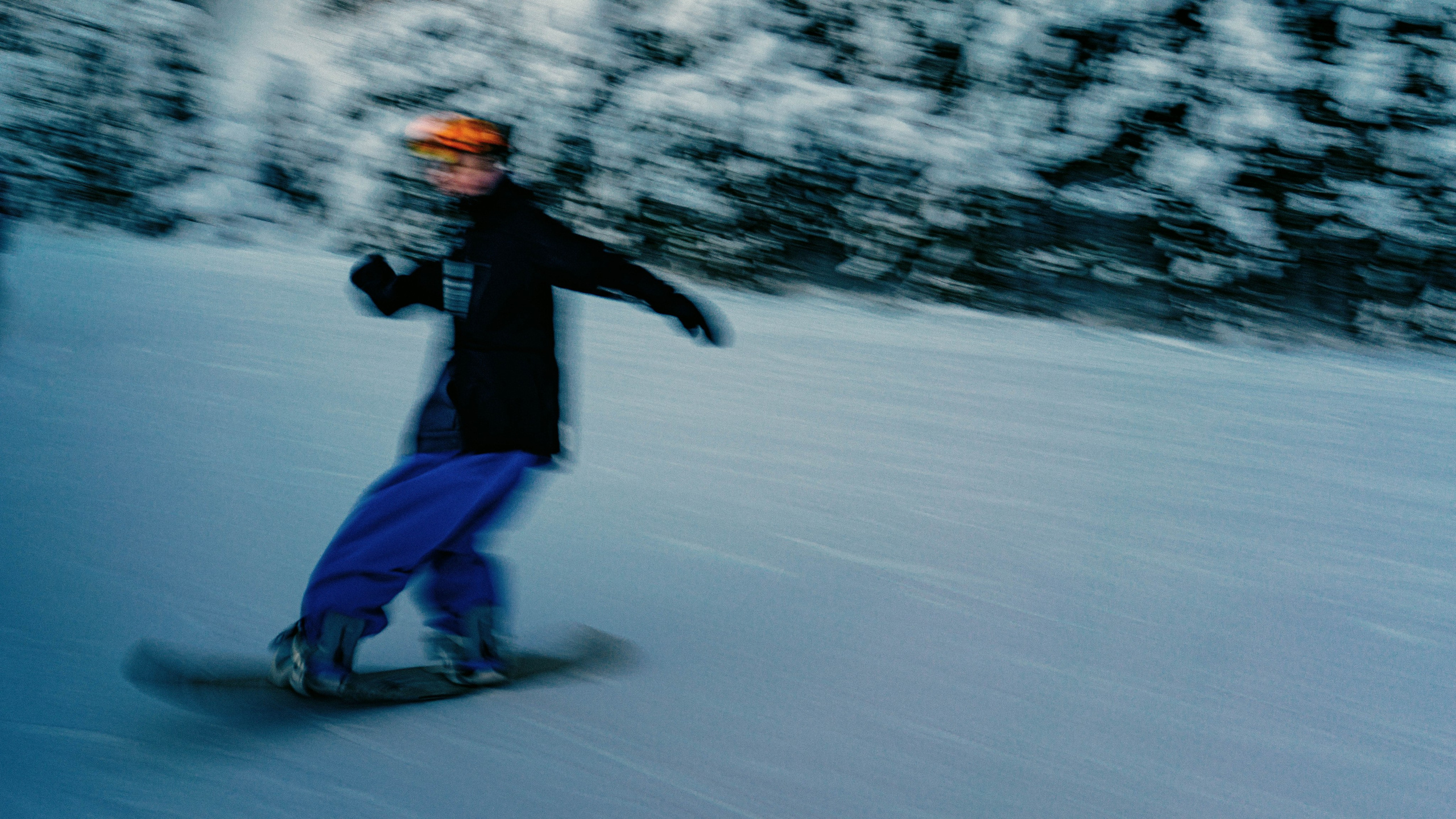 Сноубордистка выполняет фристайл трюк drive spin на снежном склоне. 