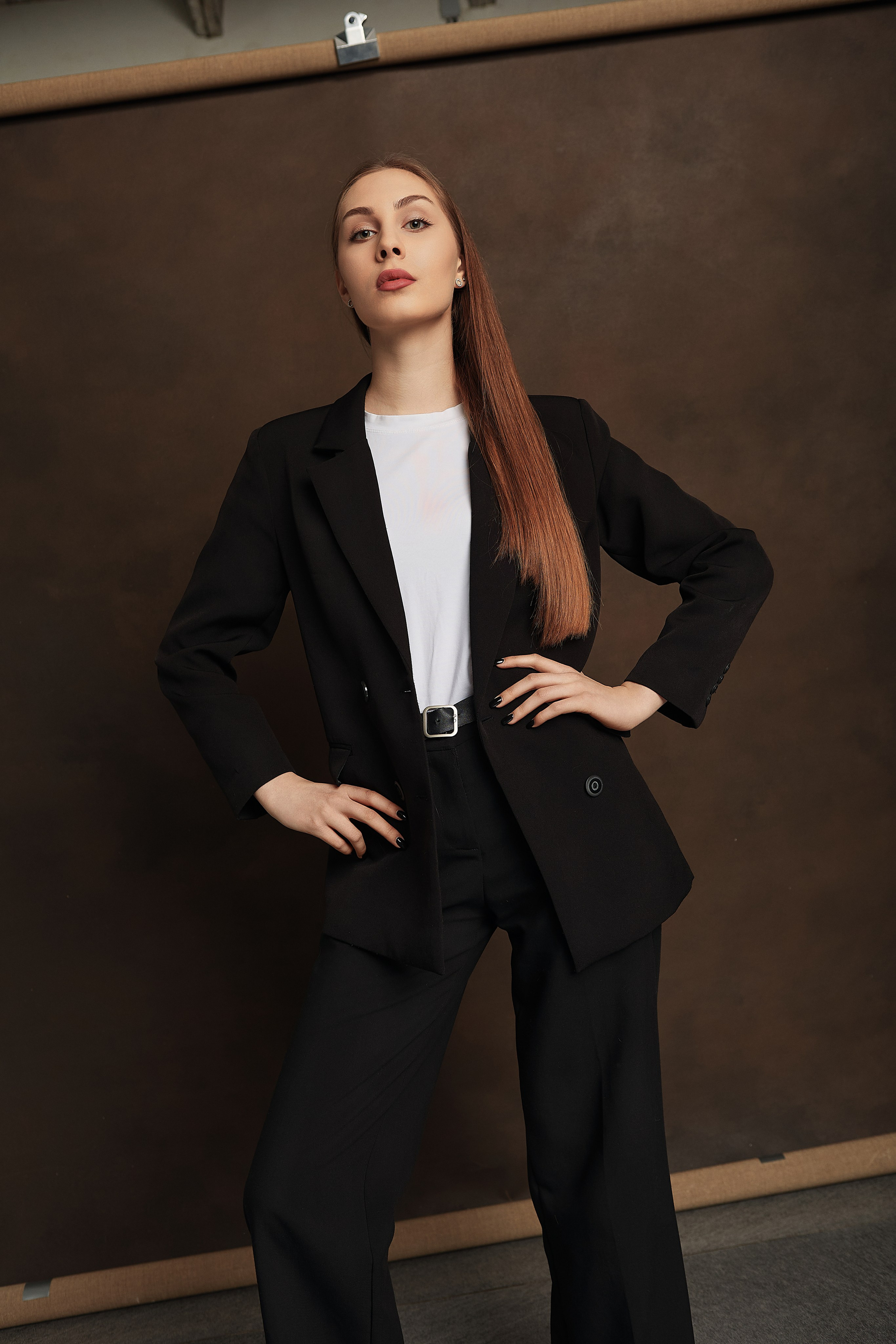 Поколенный портрет девушки в брючном костюме