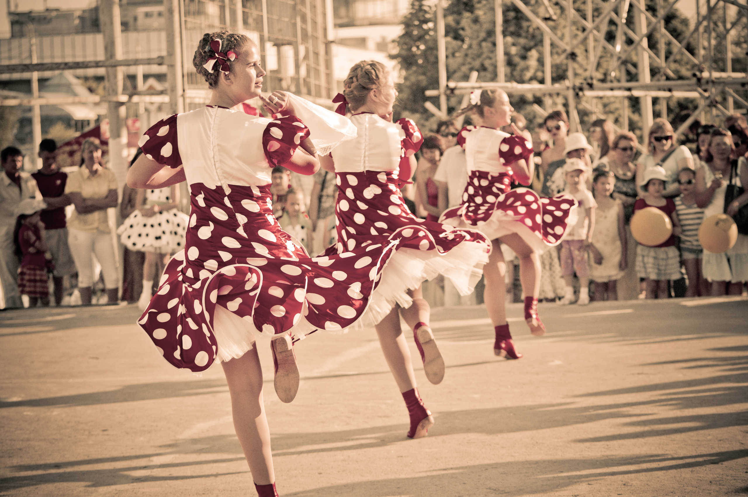 Танцевальный коллектив девушек в красных платьях во время выступления на сцене