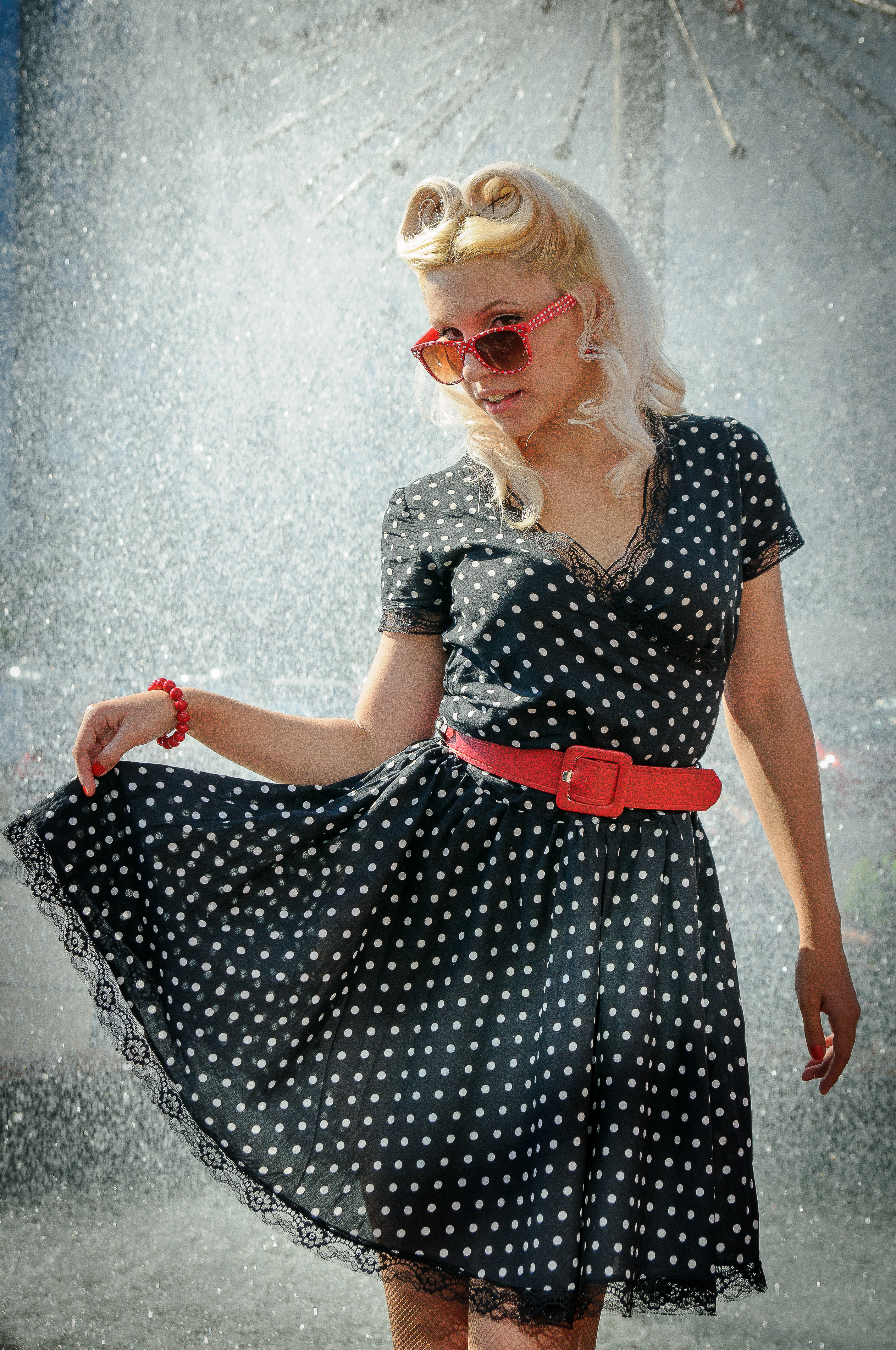 Девушка-стиляга в очках с красной оправой и в чёрном платье в горошек