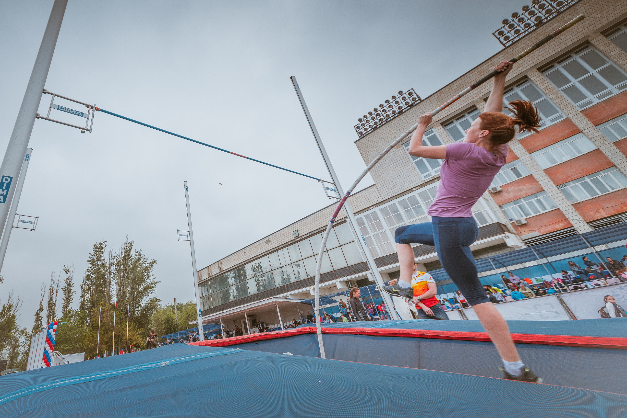 Спортсменка на соревнованиях в момент исполнения прыжка с шестом