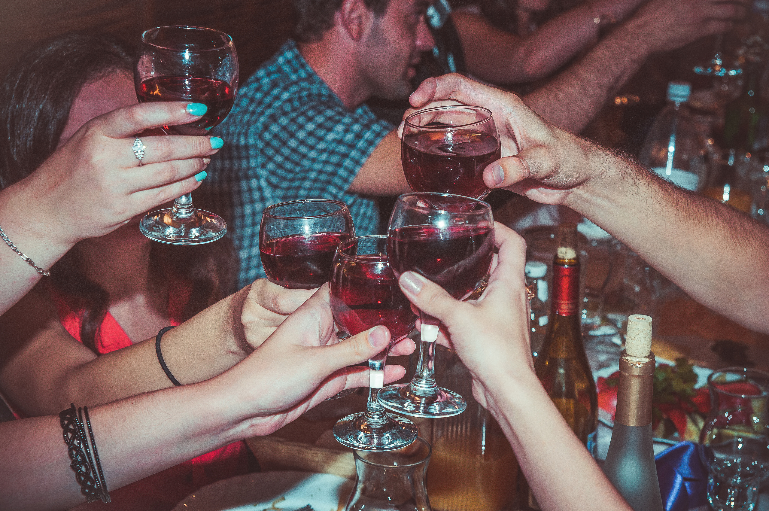 Множество рук с бокалами чокаются с друг другом на свадьбе