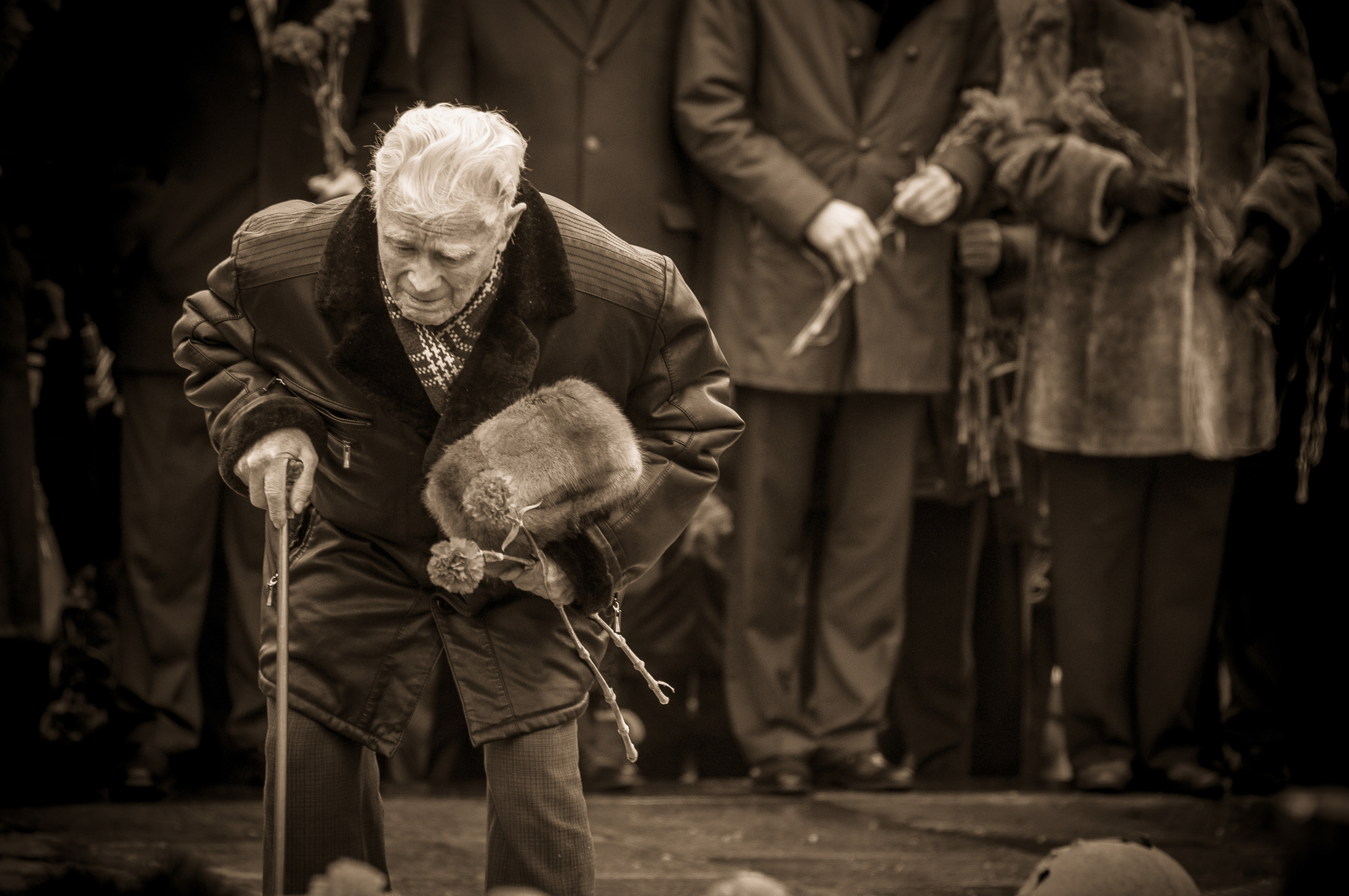 Ветеран с цветами в руках склонился над братской могилой