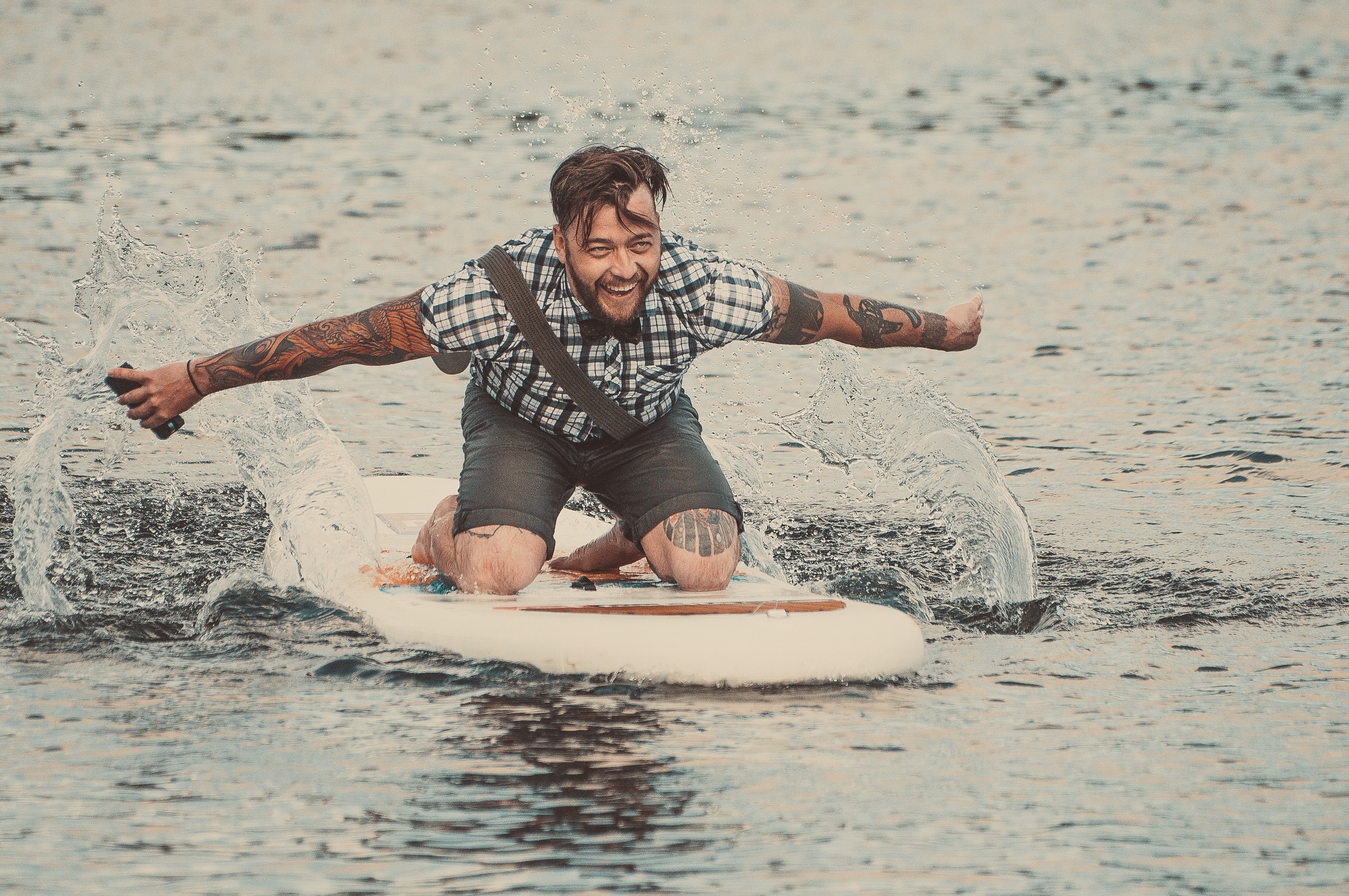 Мужчина плывёт на сапе по воде