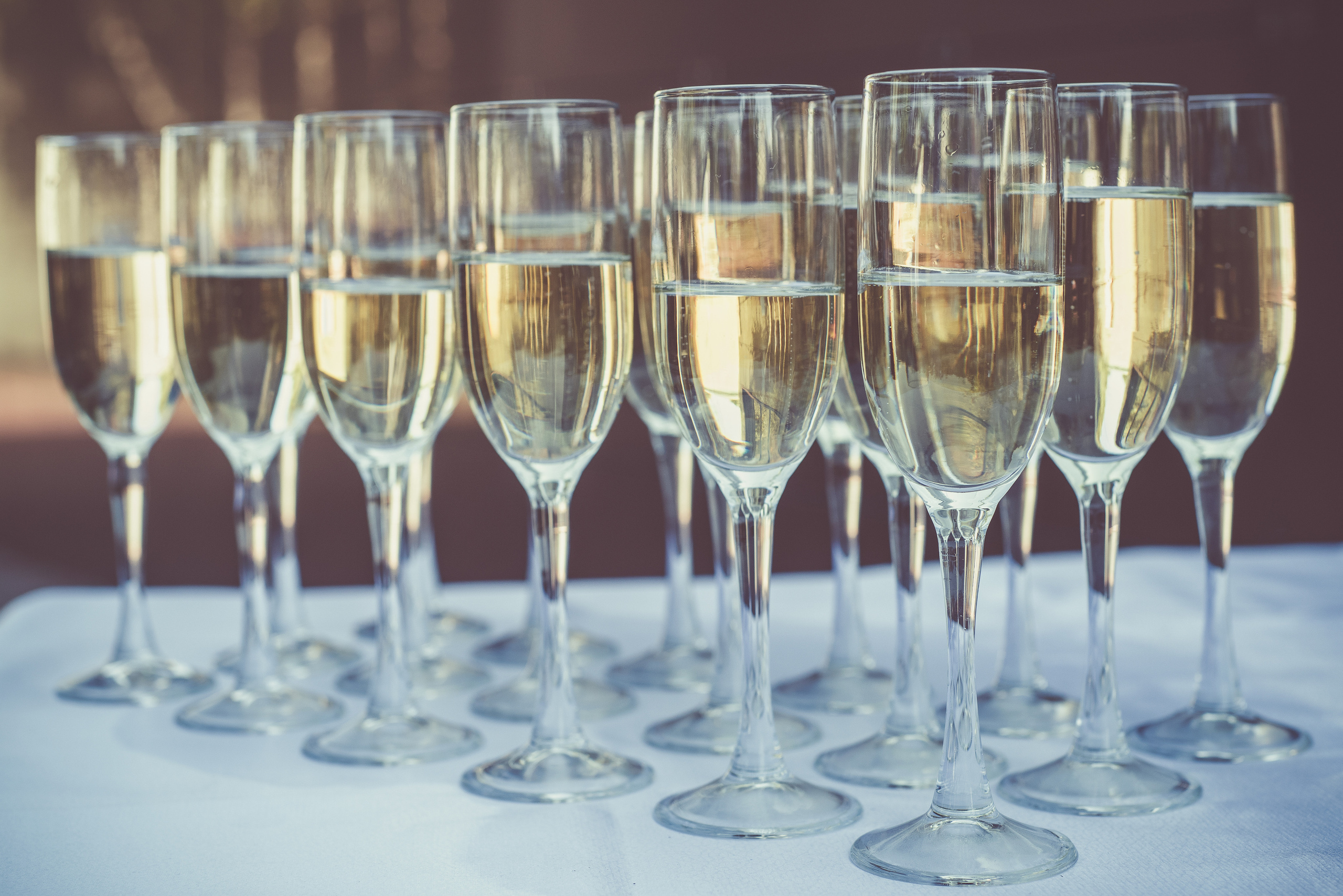 Бокалы с шампанским стоят в ряд на столе