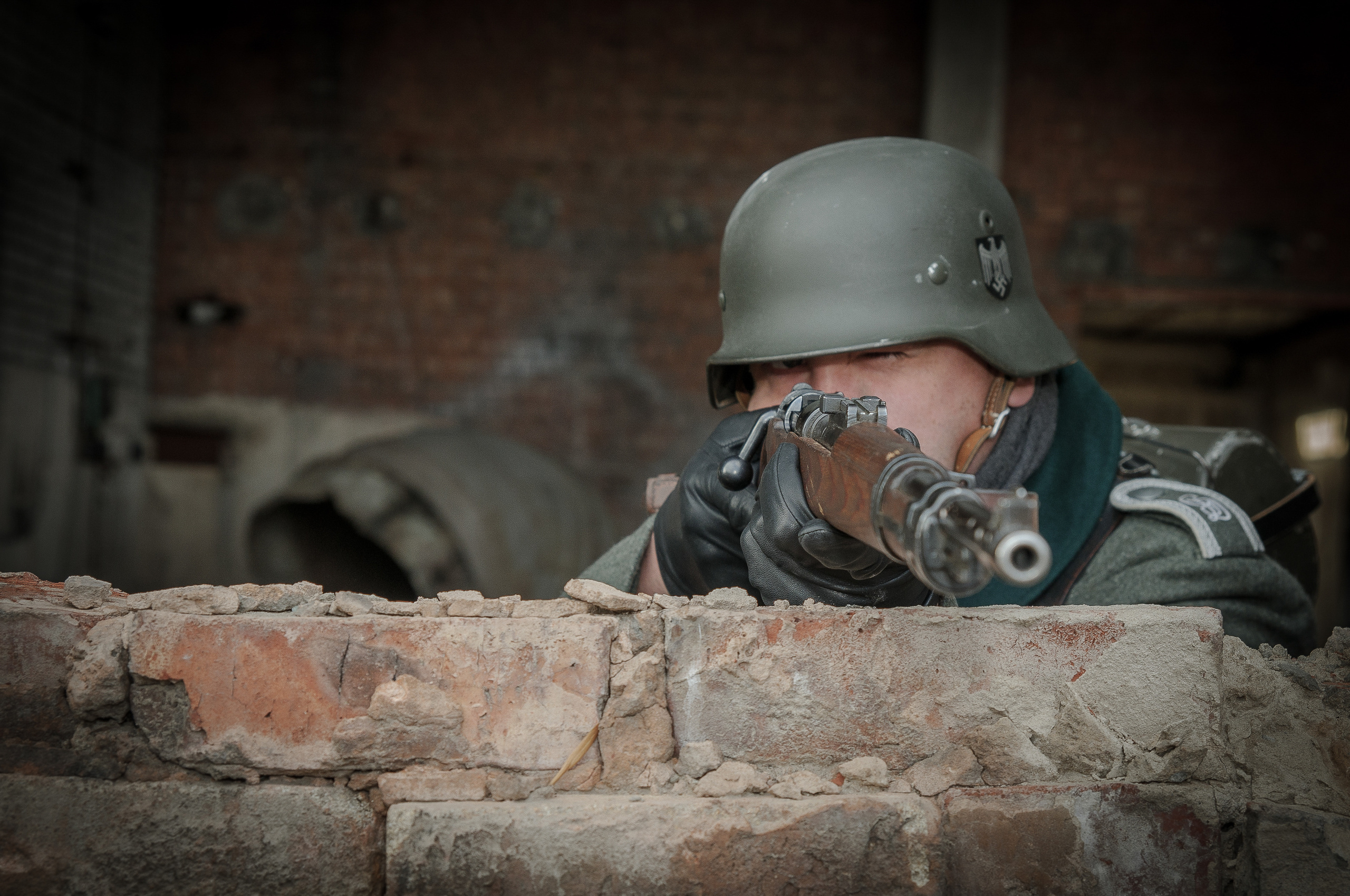 Немецкий солдат целится из оружия на исторической реконструкции