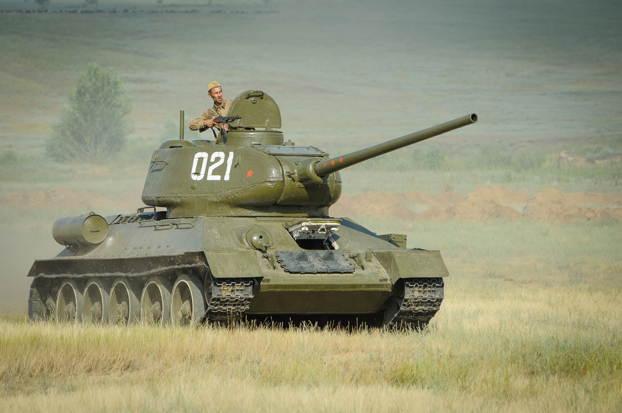 Советский танк едет по полю, солдат стреляет из автомата