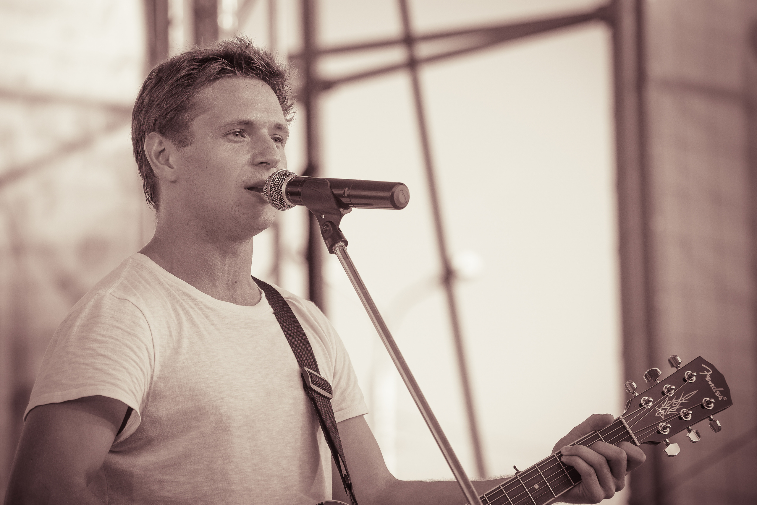 Ваня Чебанов с гитарой у микрофона во время концерта