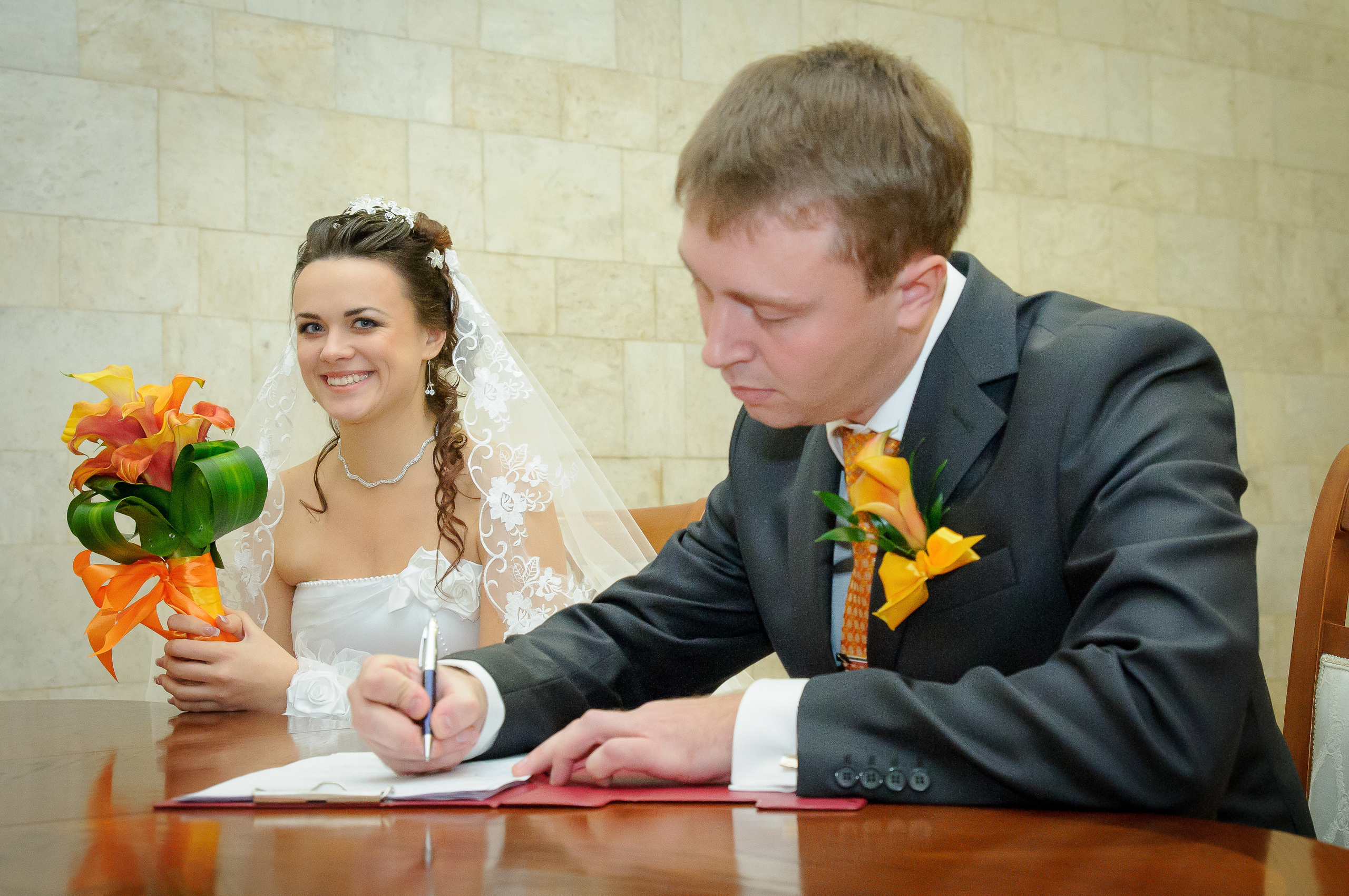 Жених ставит подпись во время церемонии бракосочетания