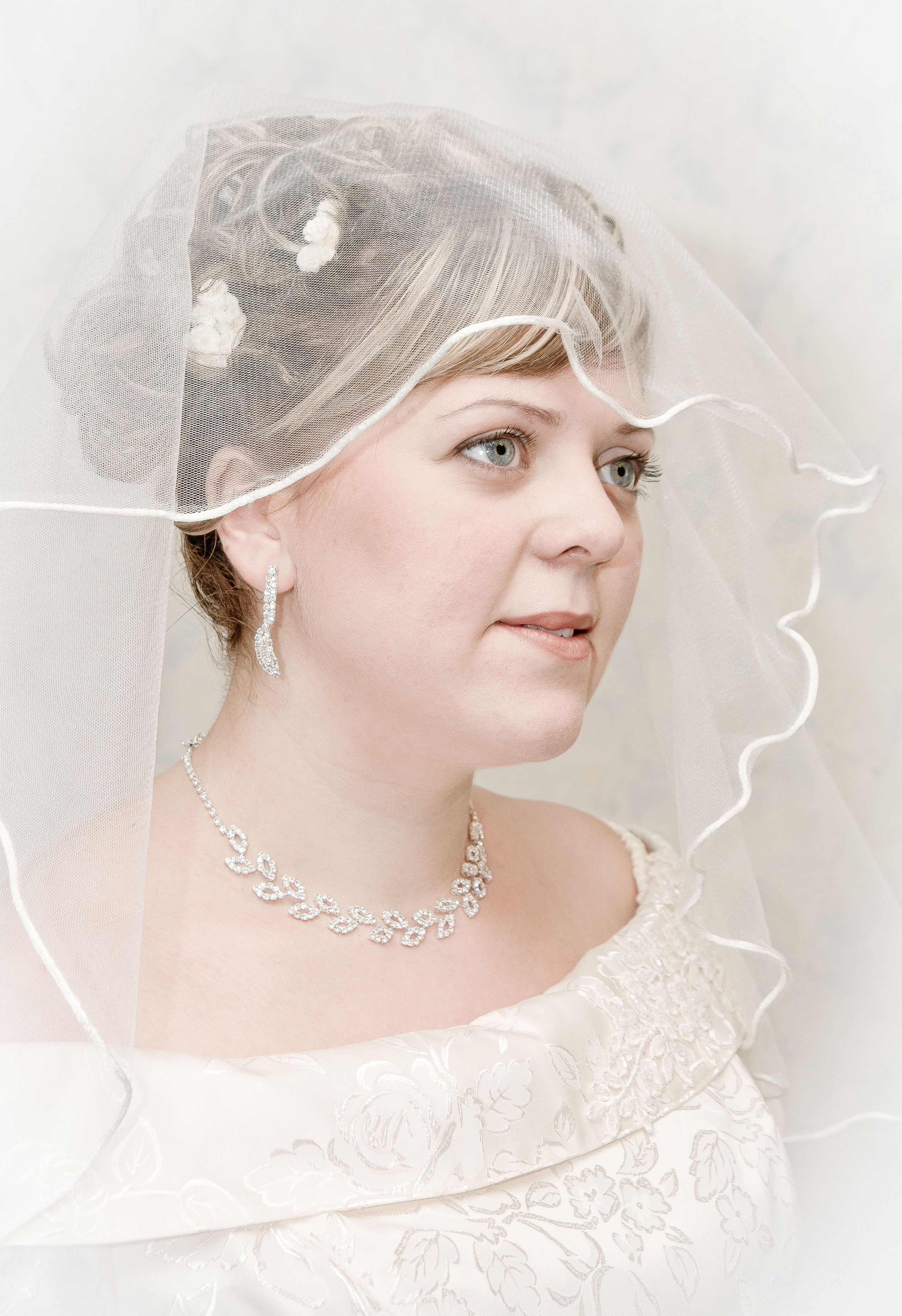 Невеста в фате на белом фоне в нежных тонах