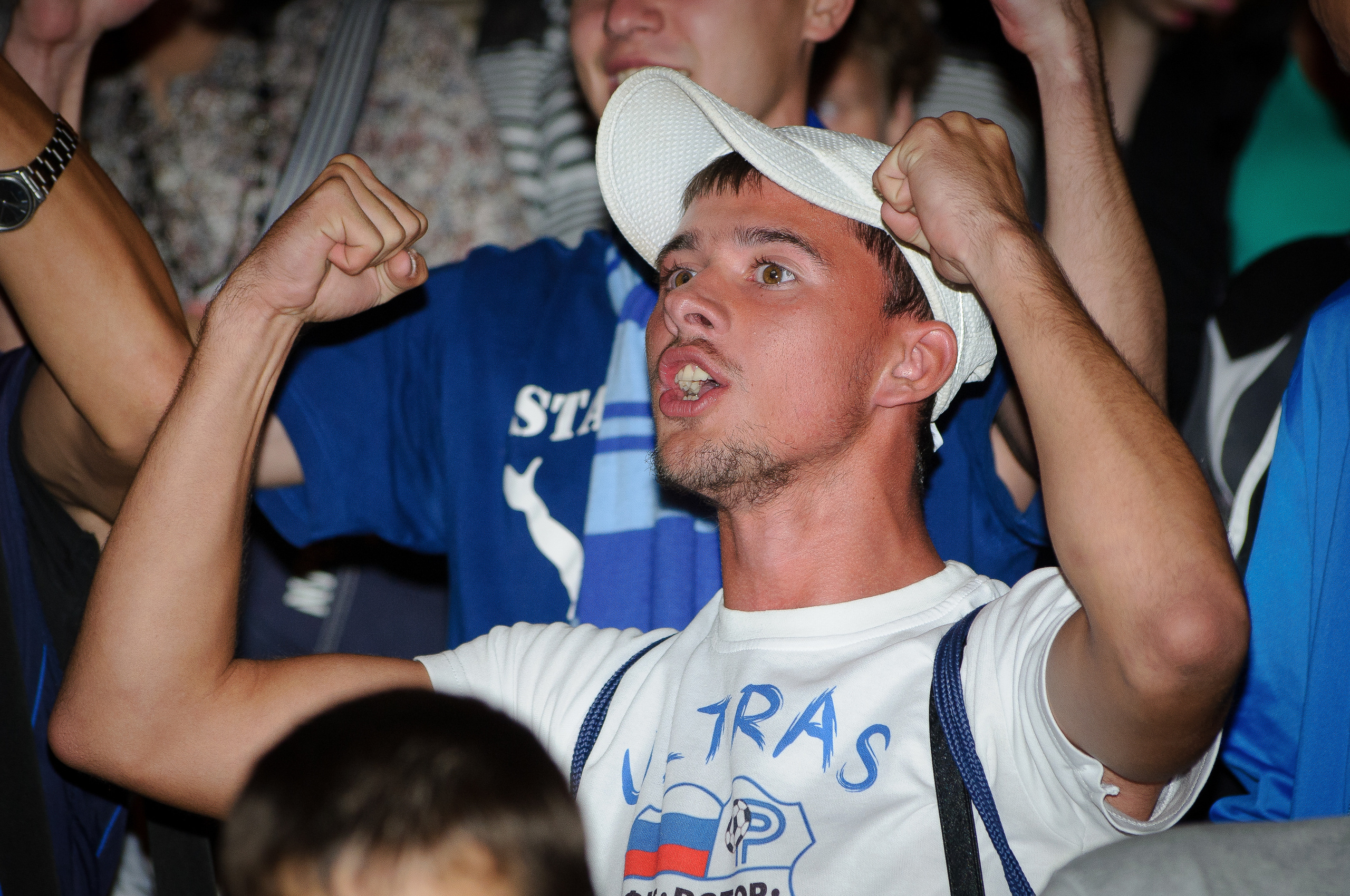 Болельщик в толпе болеет за свою команду