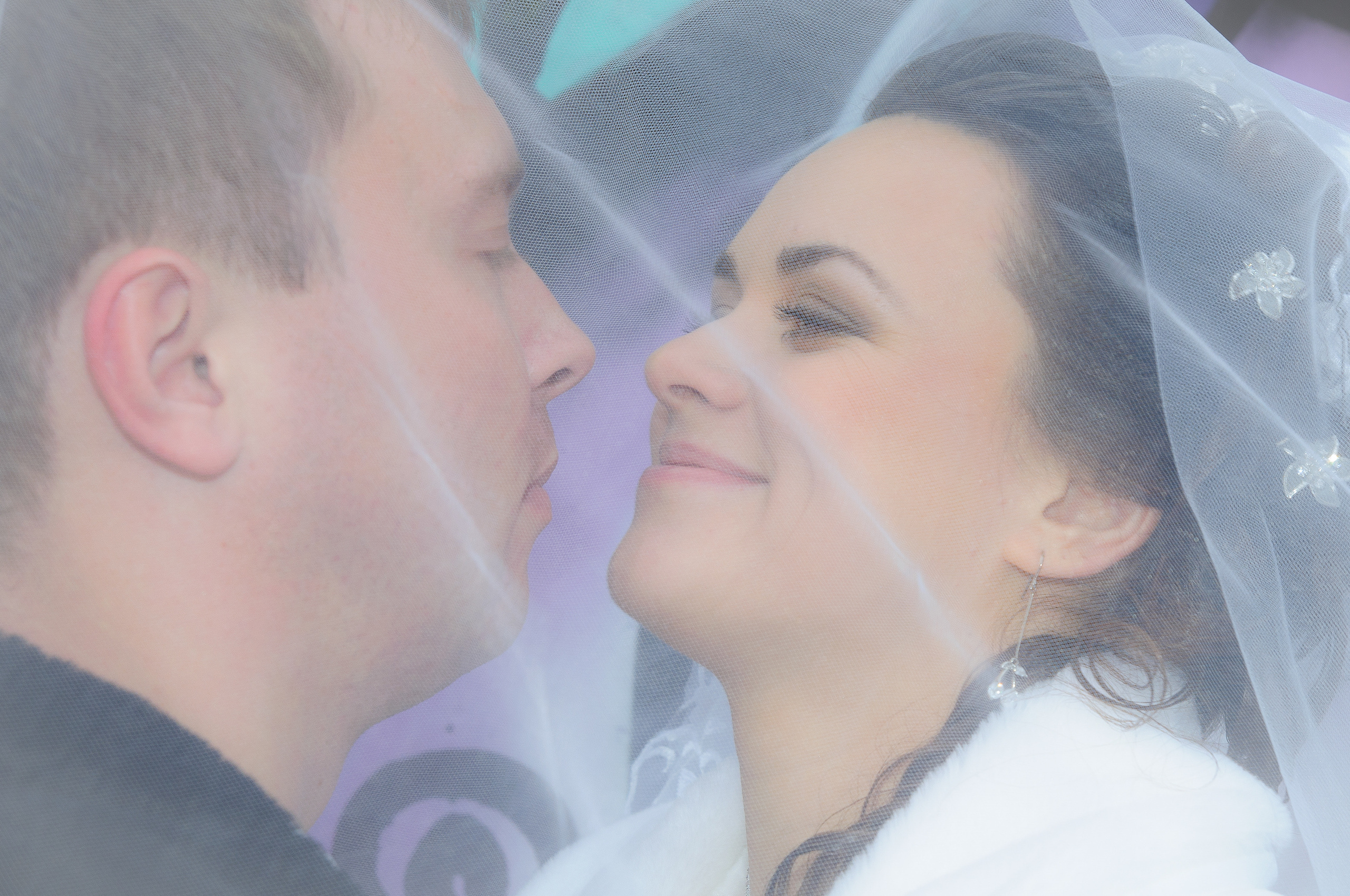 Жених и невеста под фатой улыбаются