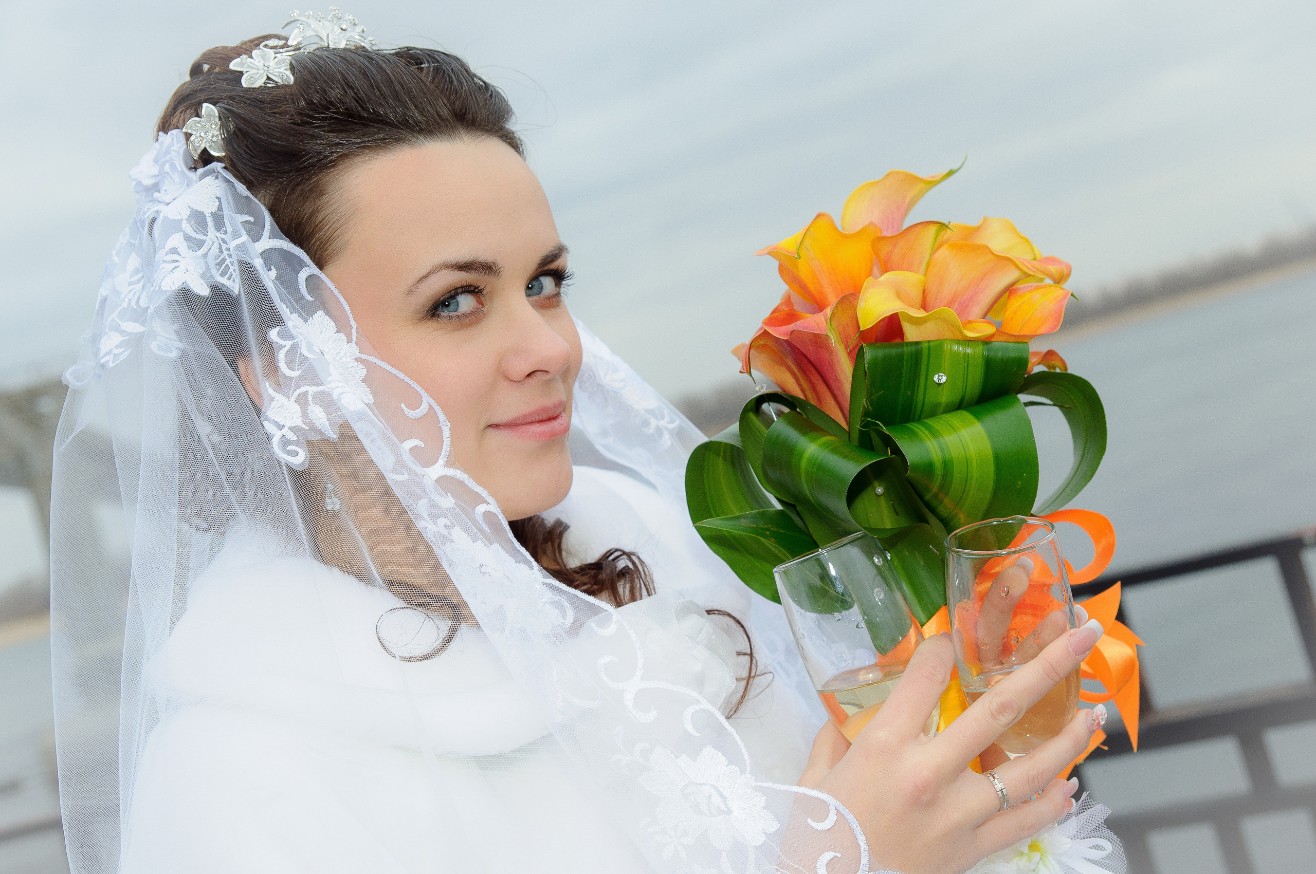Невеста со свадебными букетом с оранжевыми цветами в руках