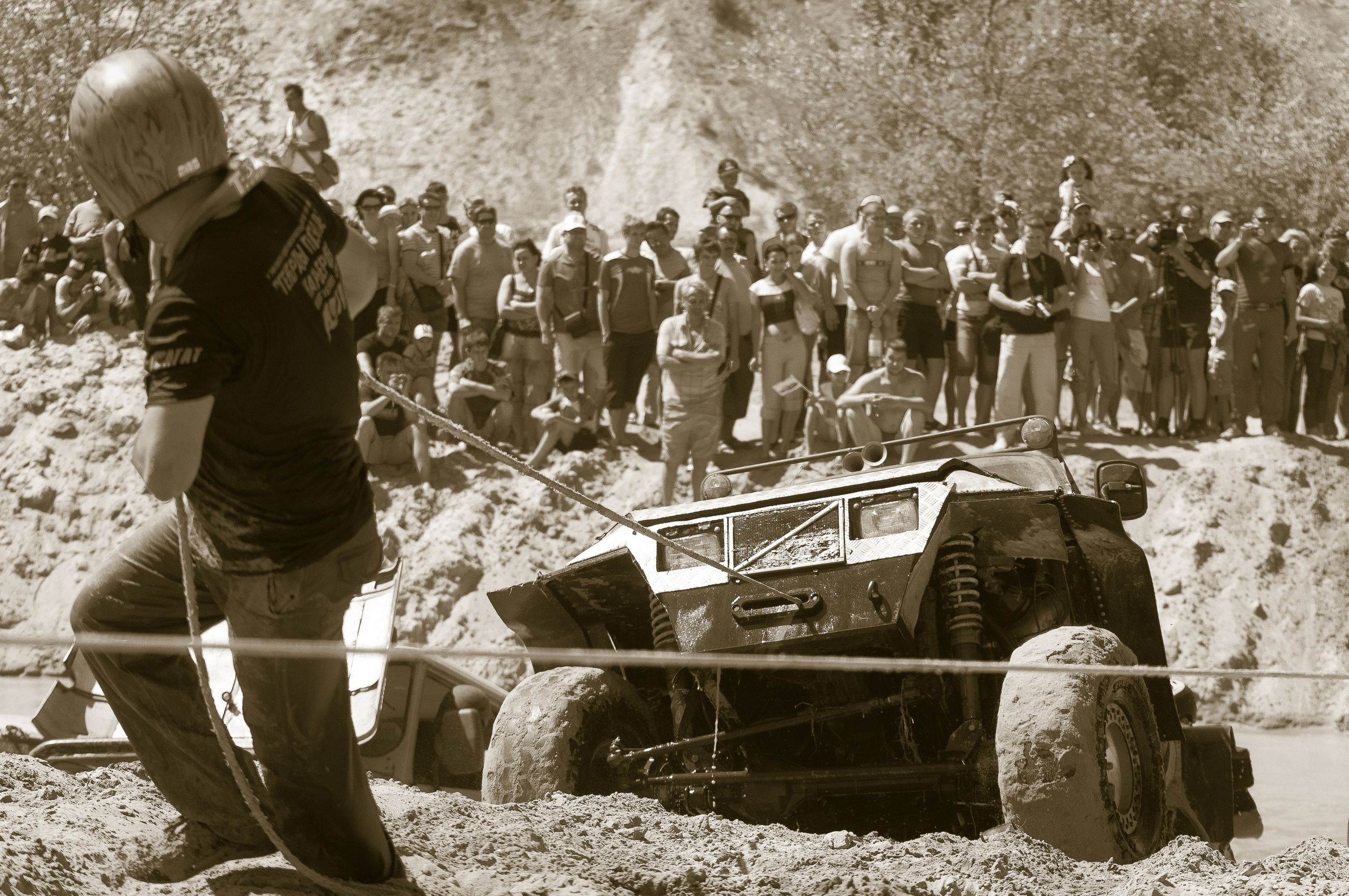 Спортсмен в шлеме вытаскивает тросом автомобиль из болота. "Генералы песчаных карьеров"