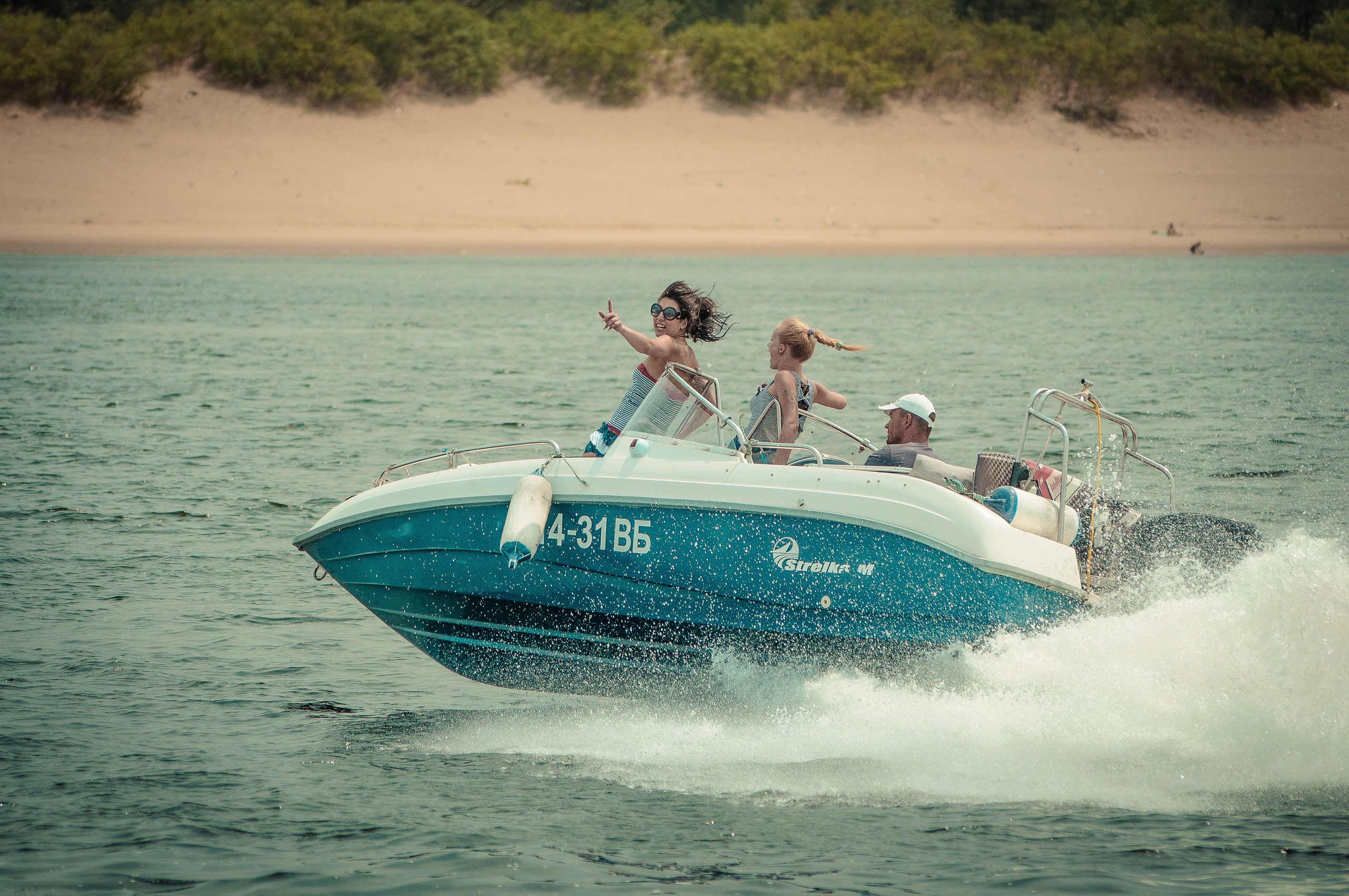 Девушки мчатся на лодке по Волге