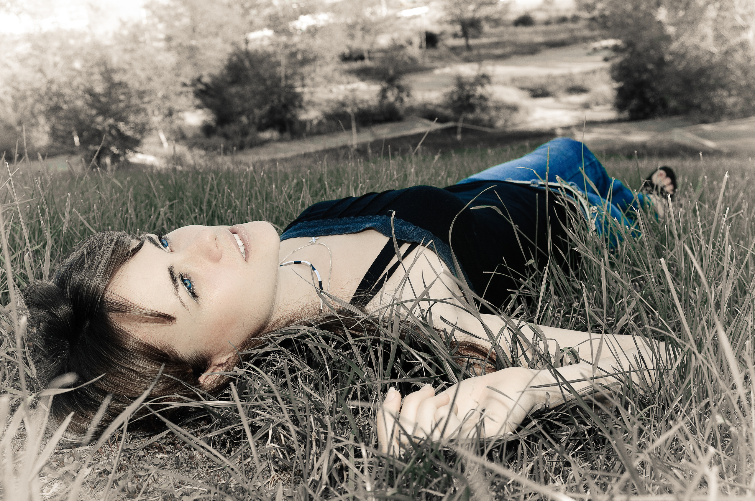 Девушка лежит на земле в траве
