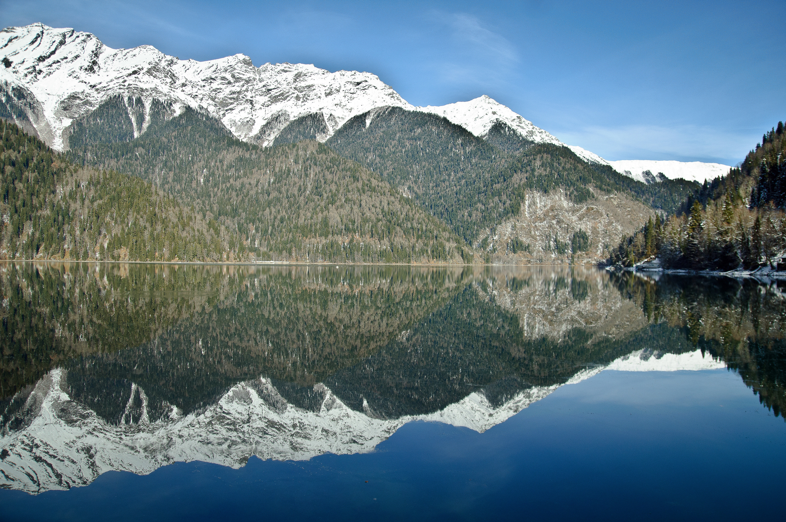 Озеро Рица в Абхазии с заснеженными горными вершинами на фоне