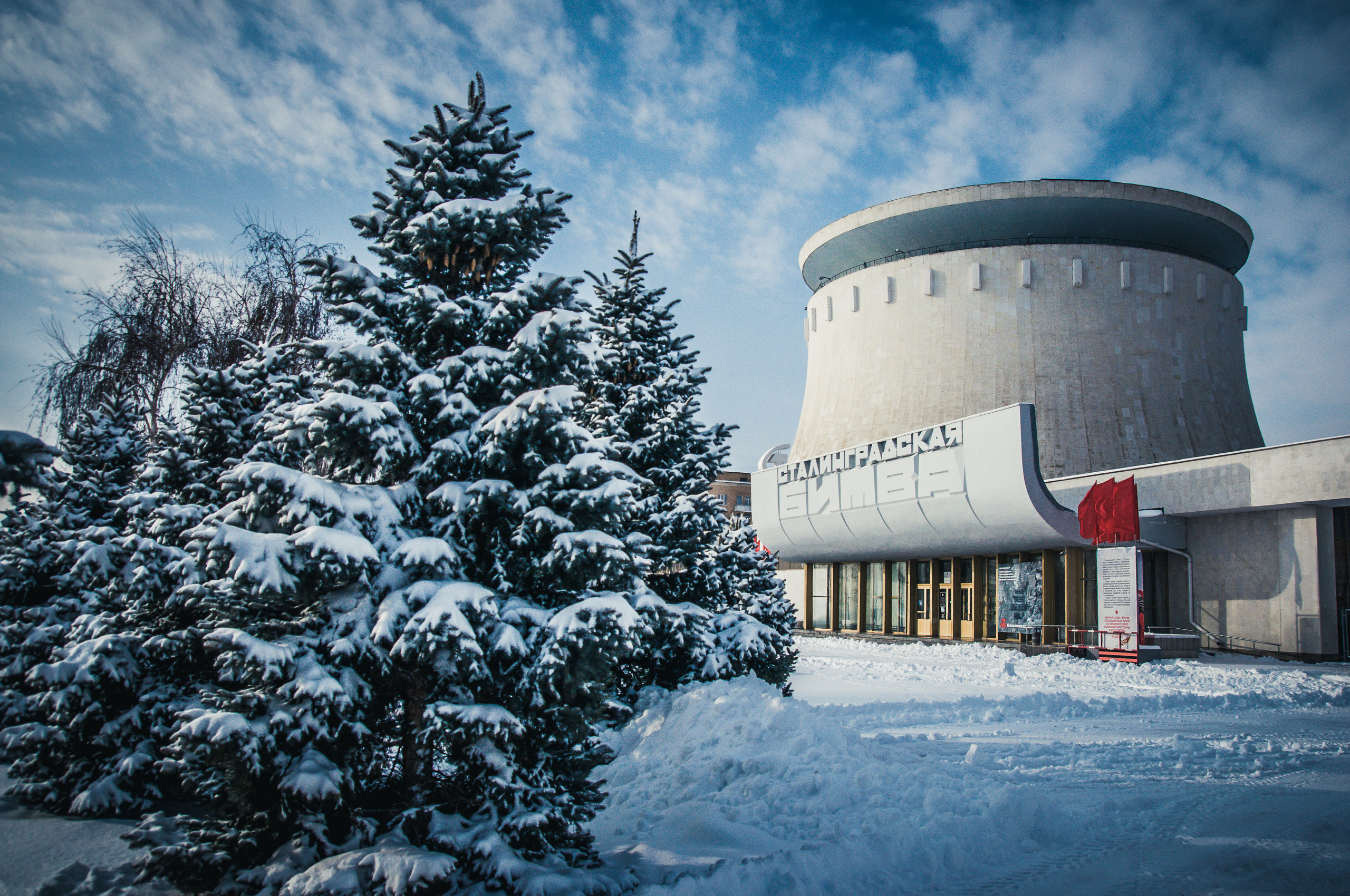 Здание Панорамы Сталинградской битвы и заснеженные ели зимой