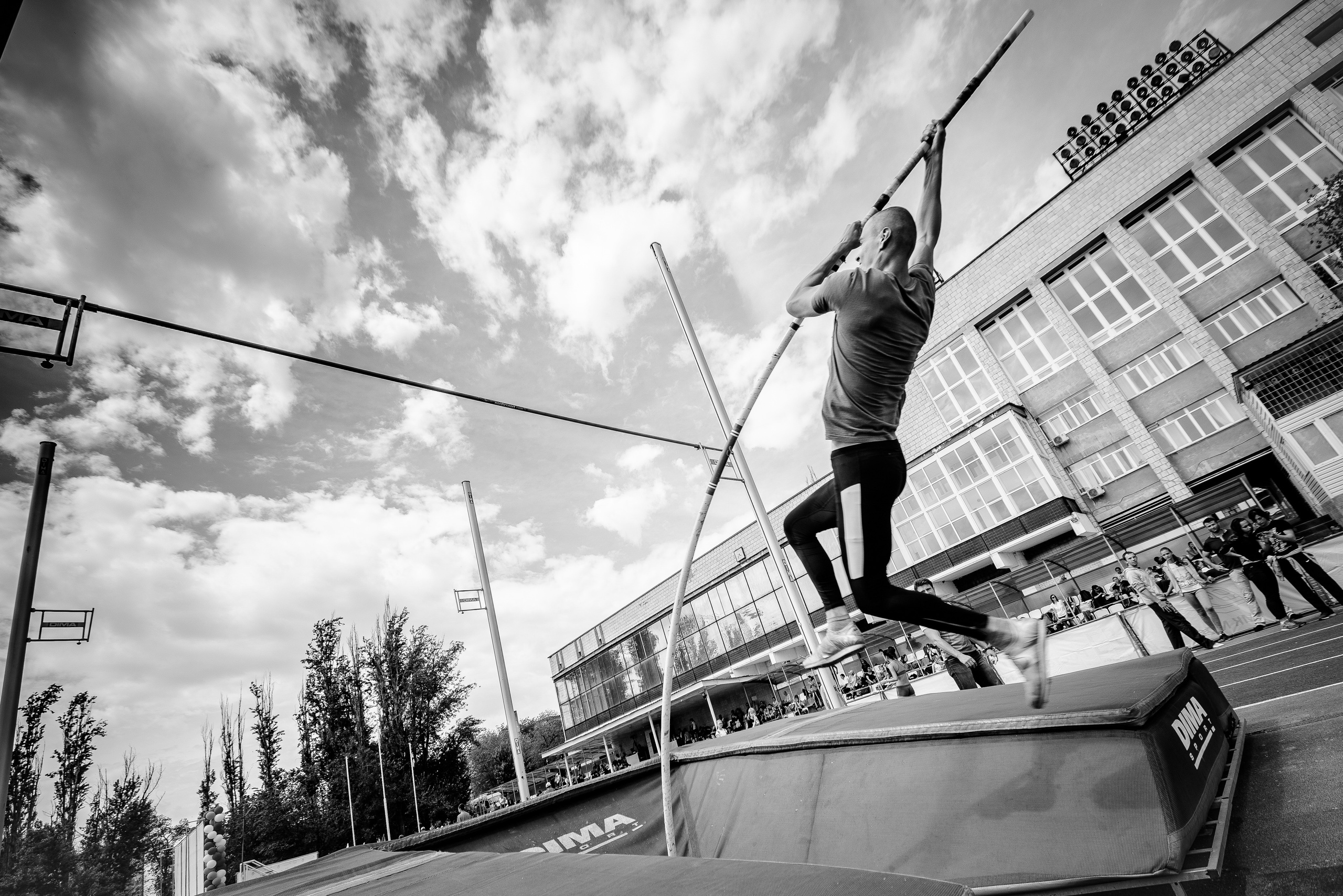 Спортсмен выполняет прыжок с шестом