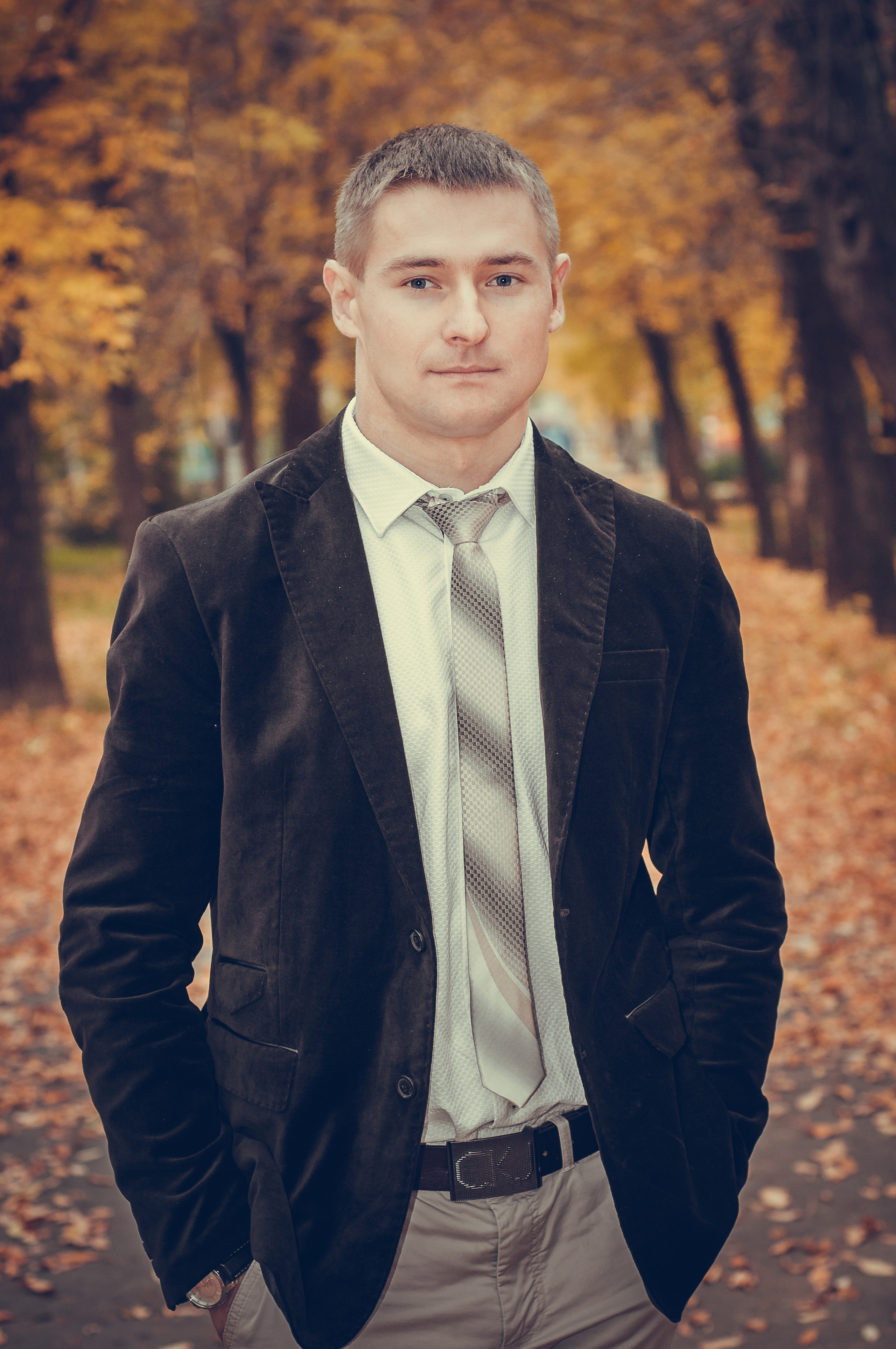 Мужчина в пиджаке и галстуке в осеннем парке