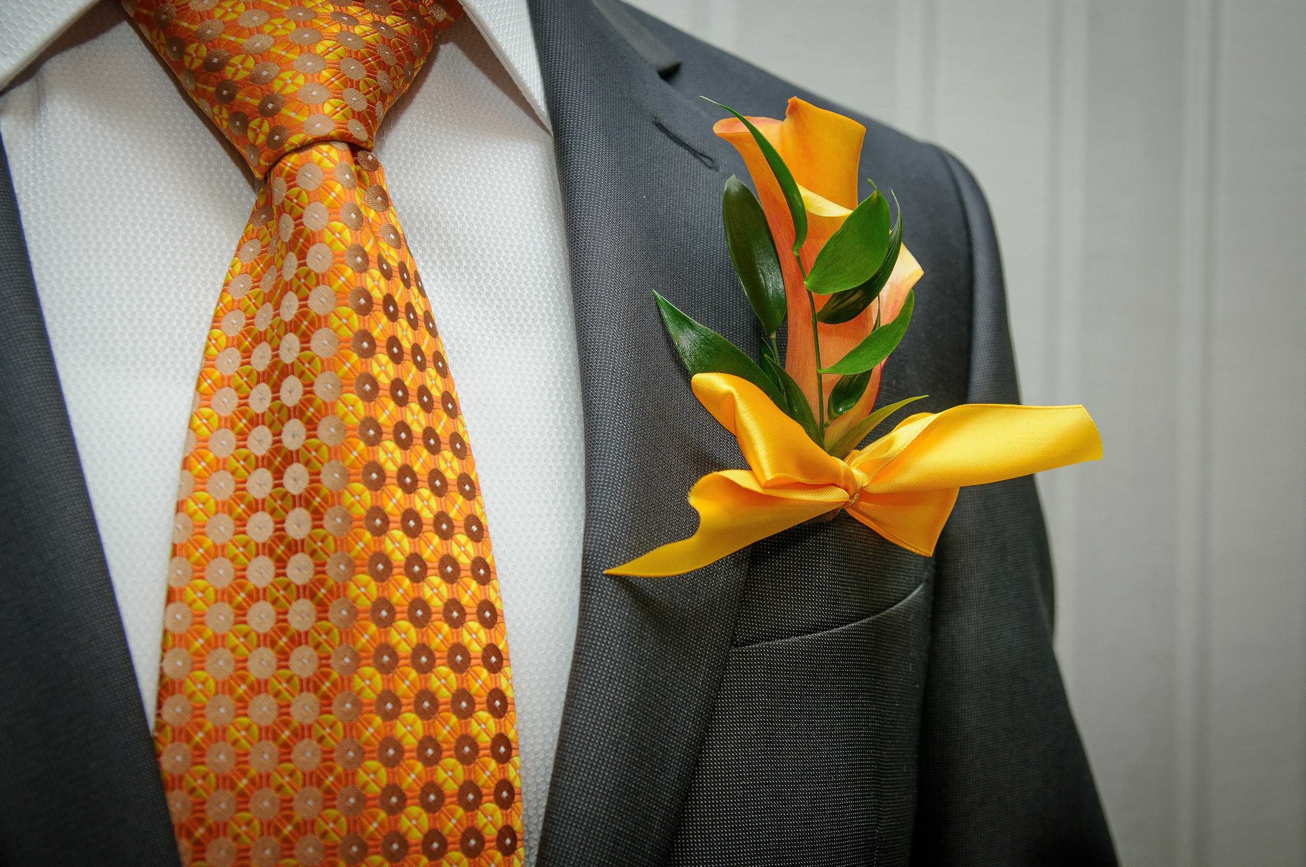 Костюм жениха с оранжевым галстуком и бутоньеркой