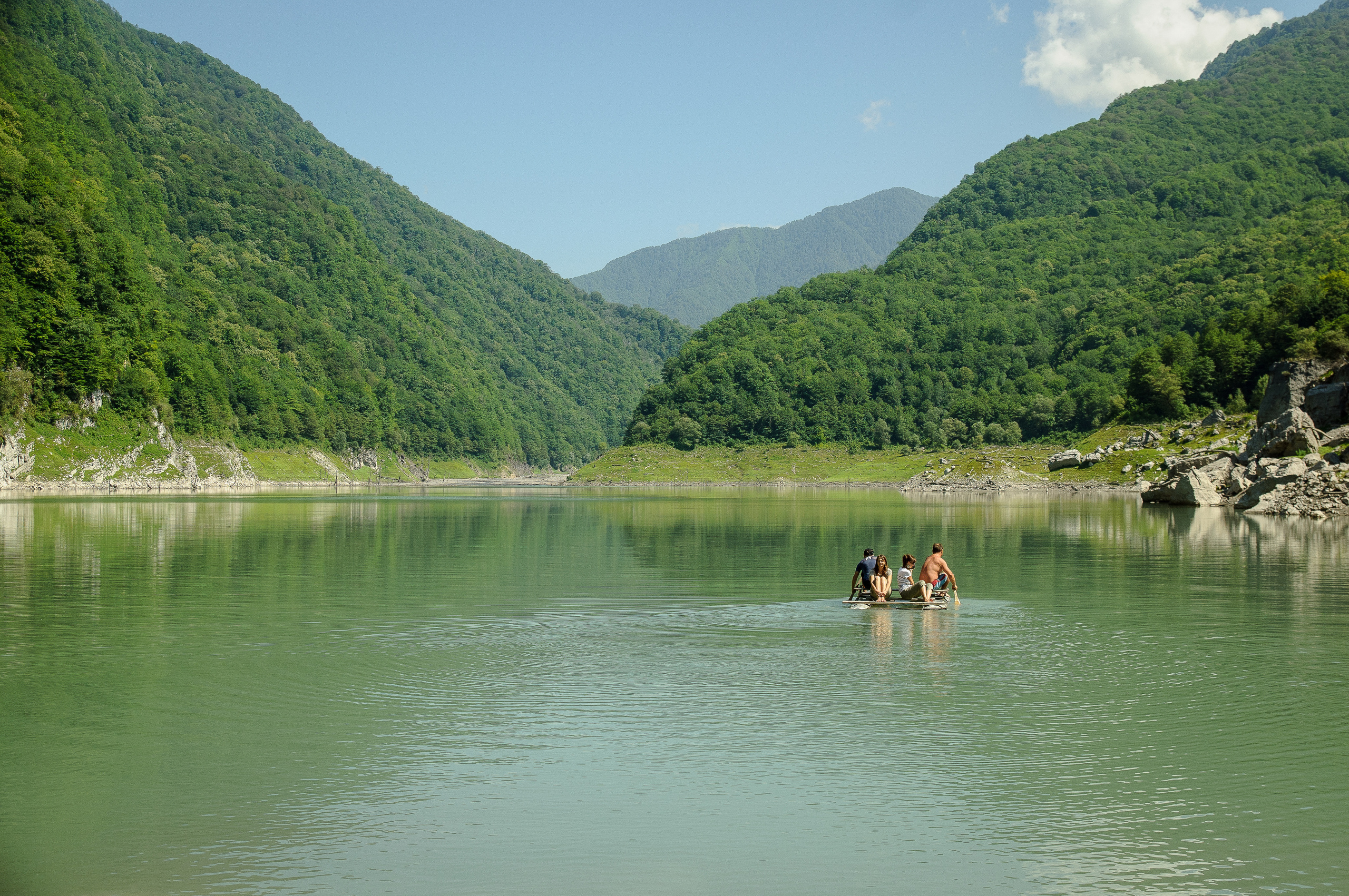 Люди на плоту плывут по высокогорному озеру Амткел в Абхазии