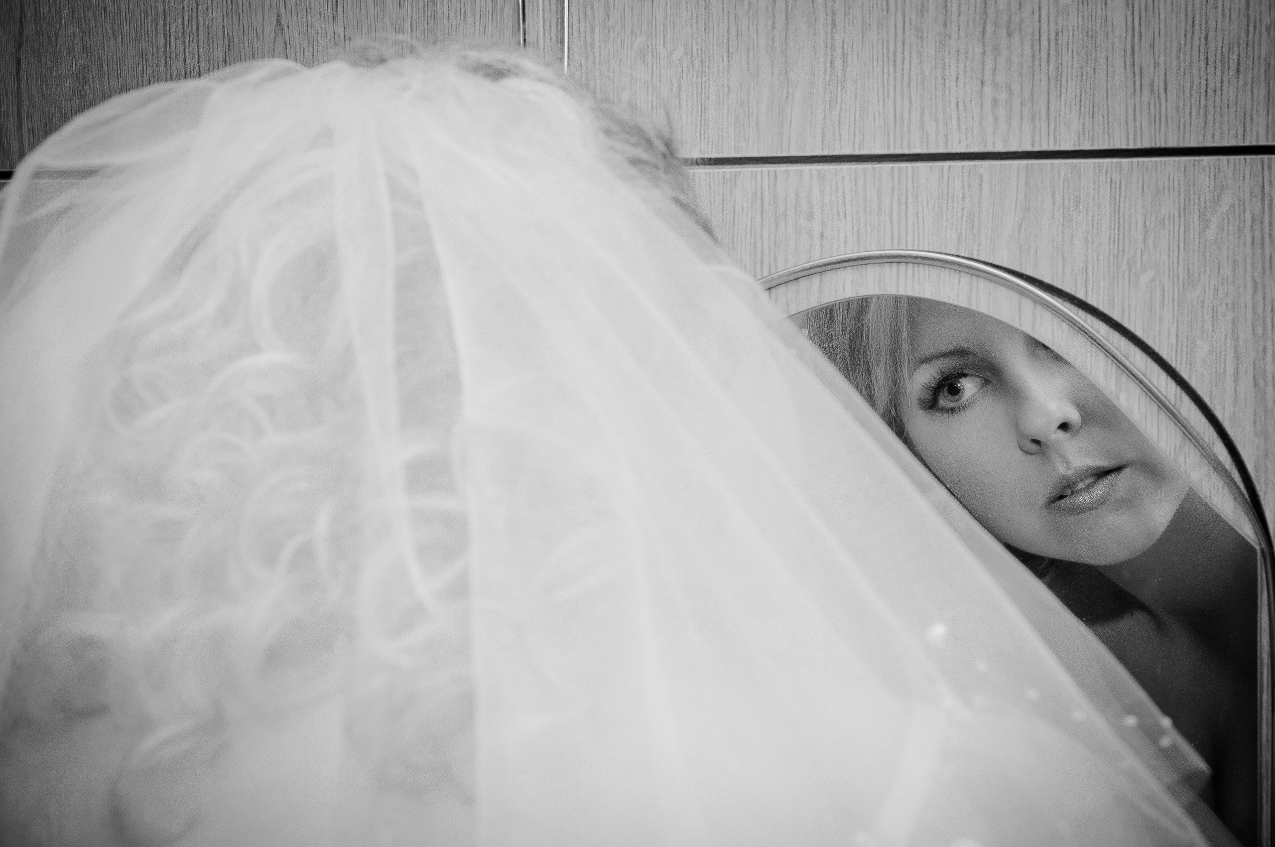 Невеста надевает серьги, глядя в зеркало