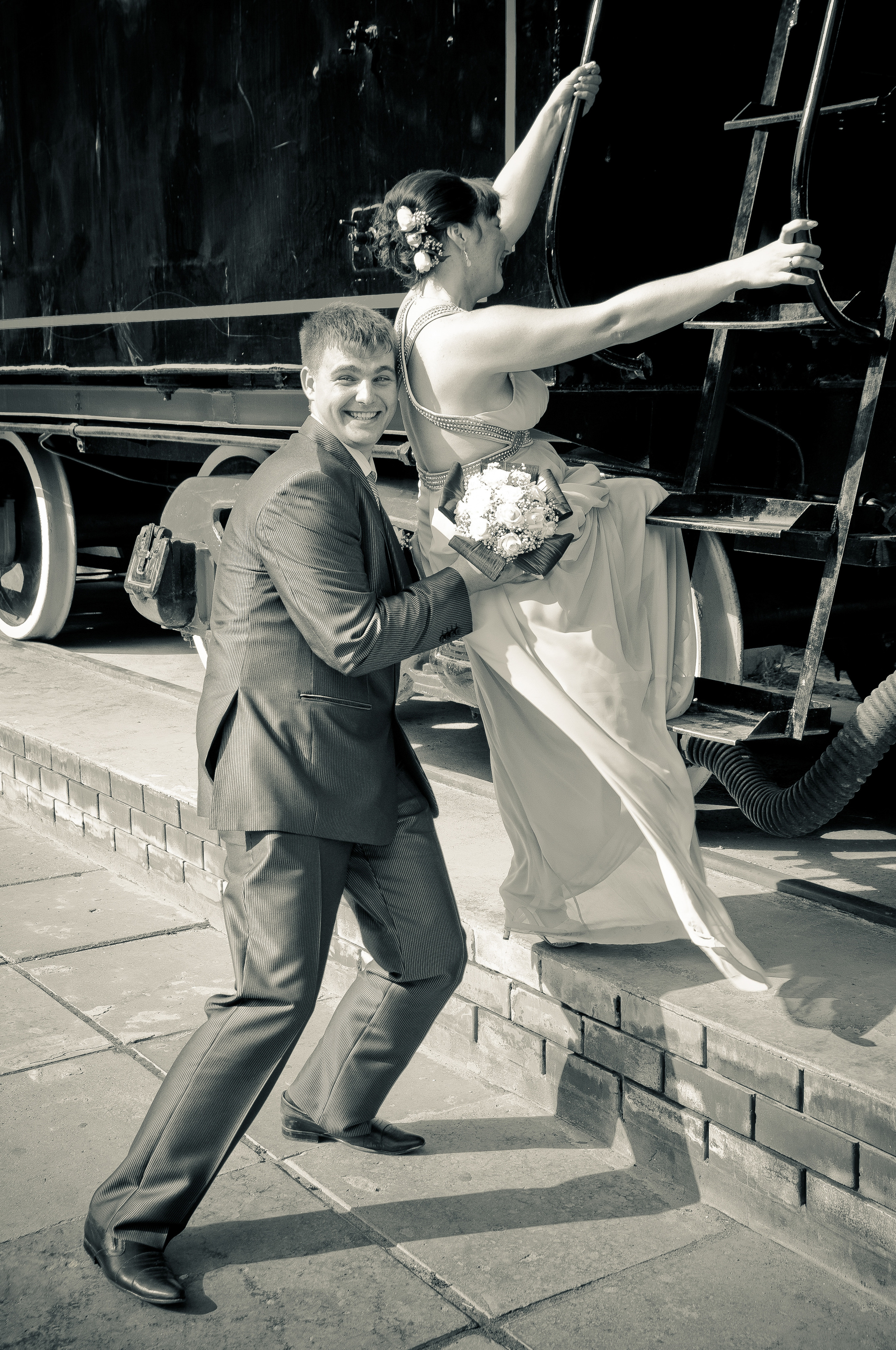 Жених помогает невесте залезть на лестницу паровоза