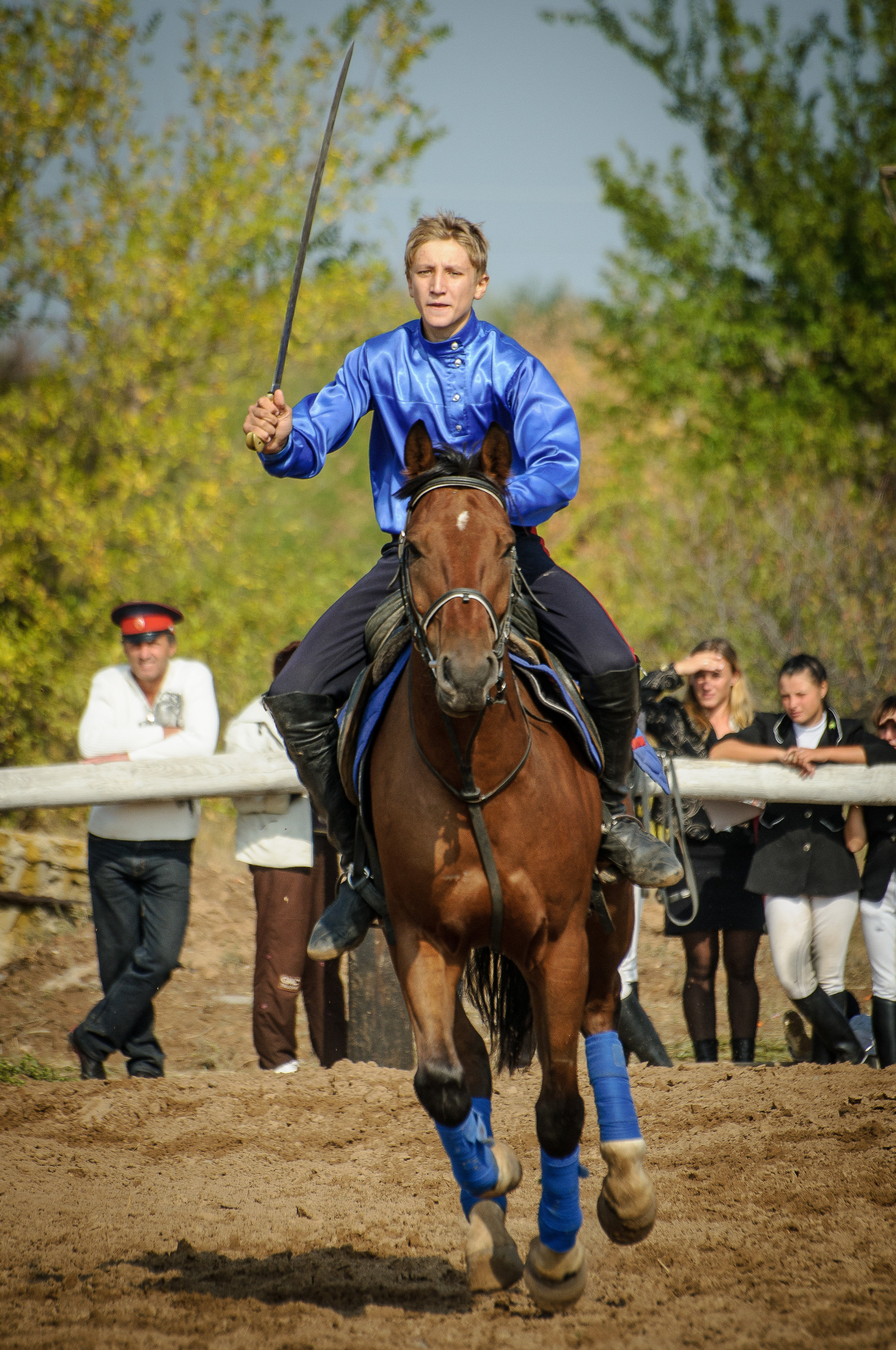 Мальчик в синей рубашке скачет на коне с шашкой в руке