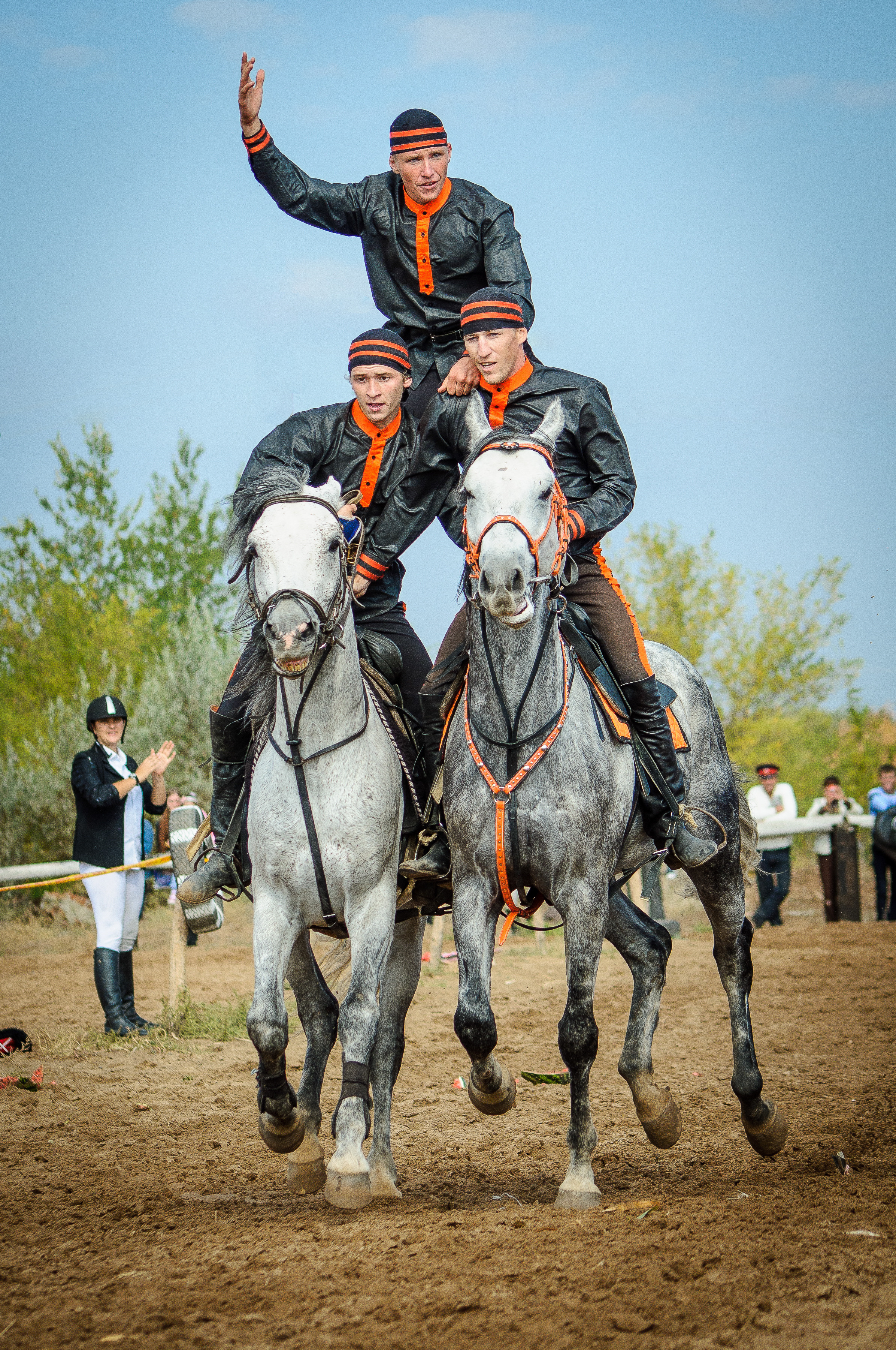 Три казака скачут на двух конях во время джигитовки