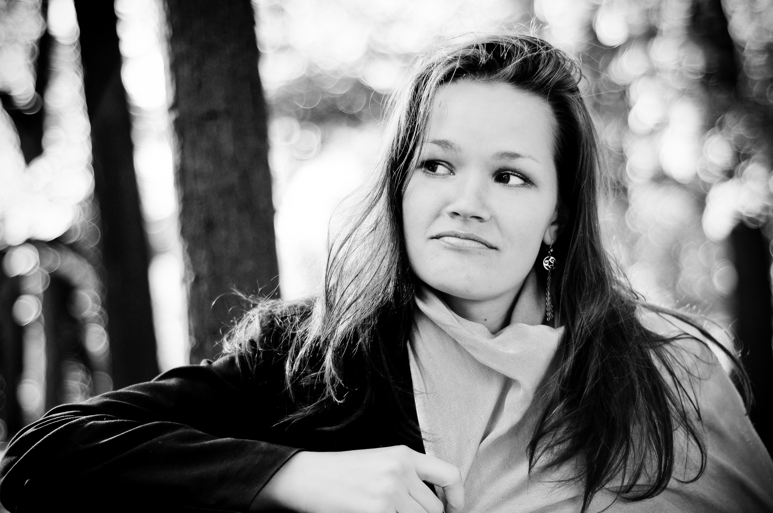 Девушка сидит в парке на скамейке