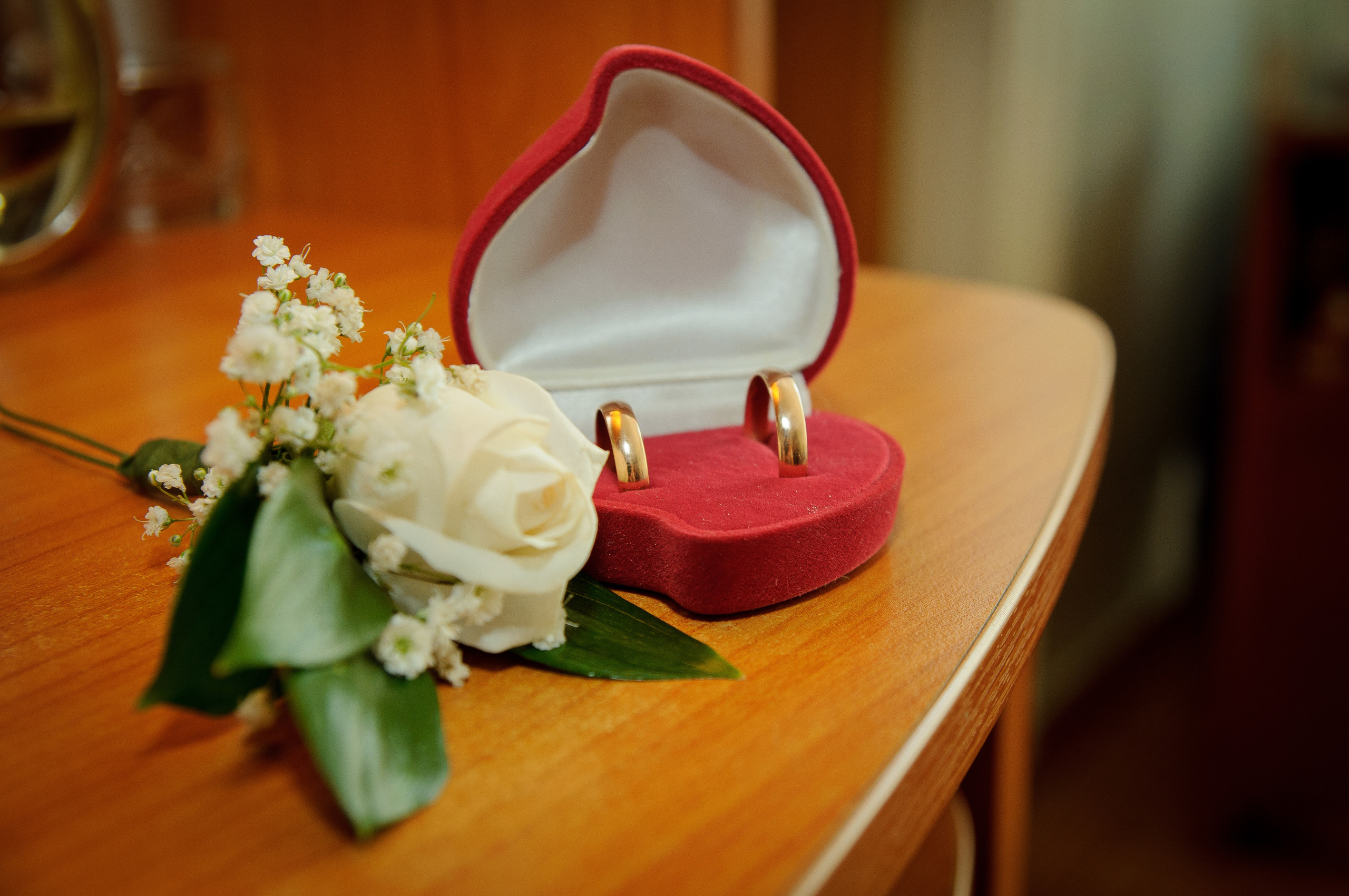 Обручальные кольца и бутоньерка лежат на столе