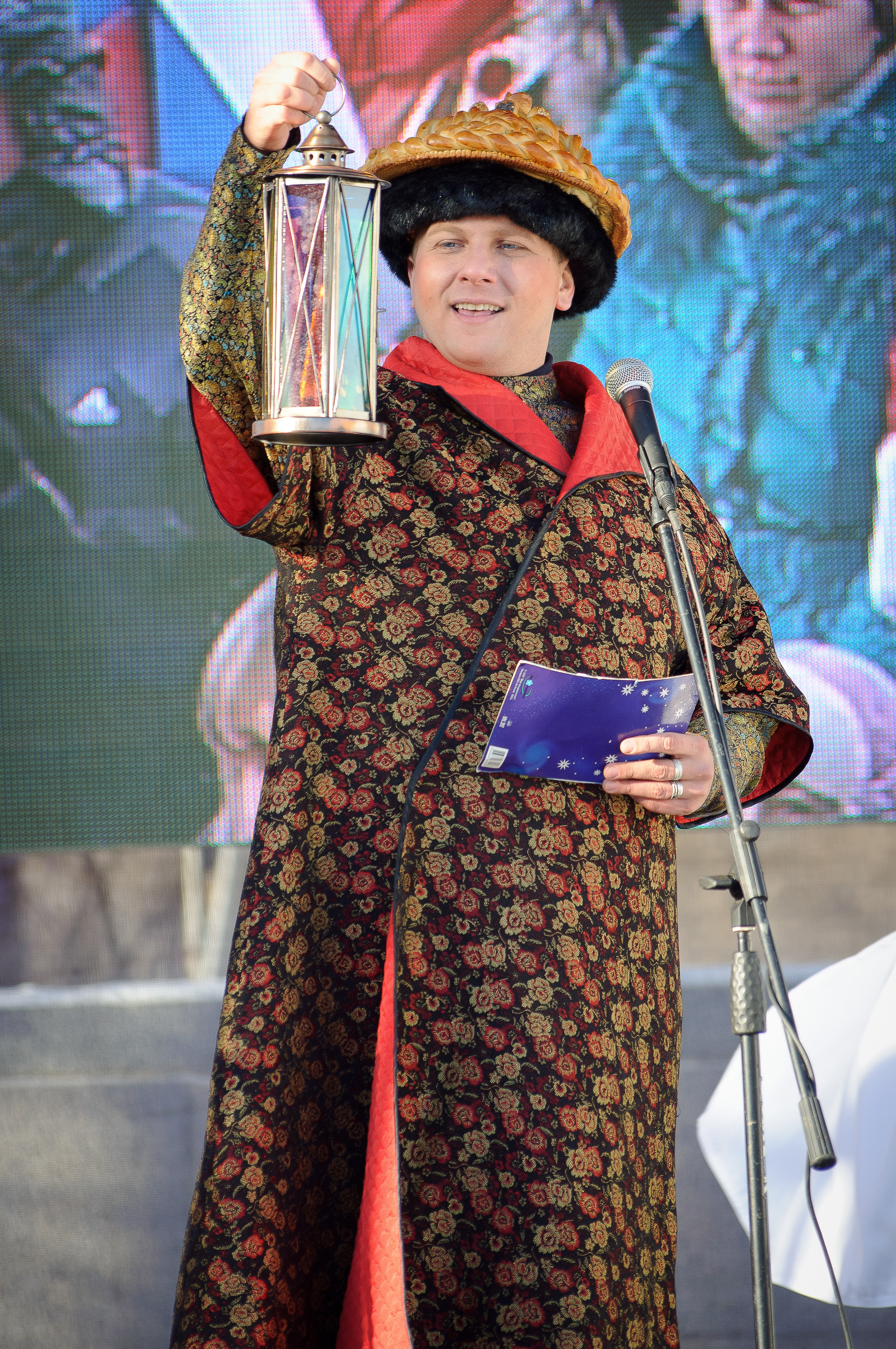 Мужчина в историческом наряде держит перед собой фонарь