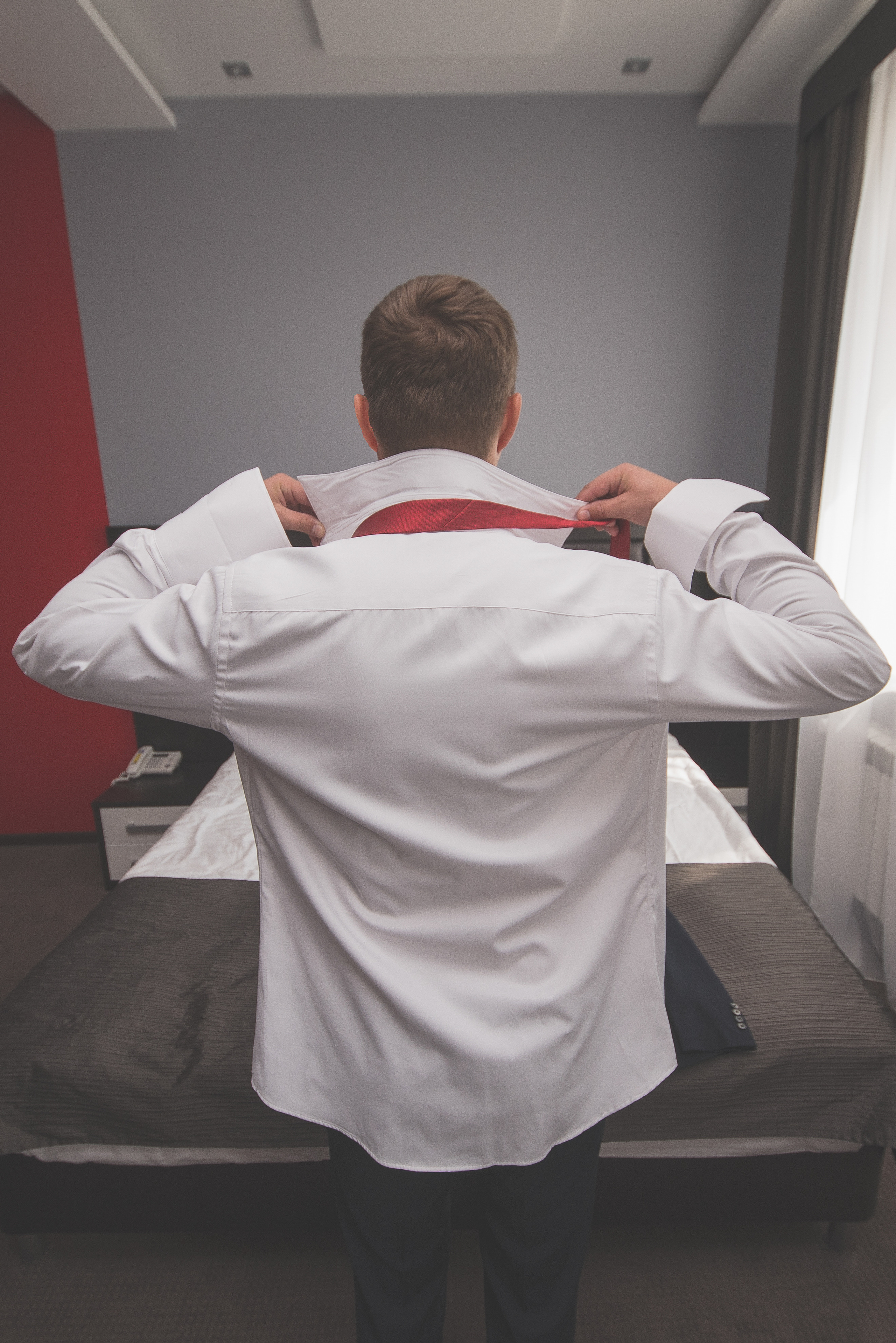 Мужчина надевает красный галстук