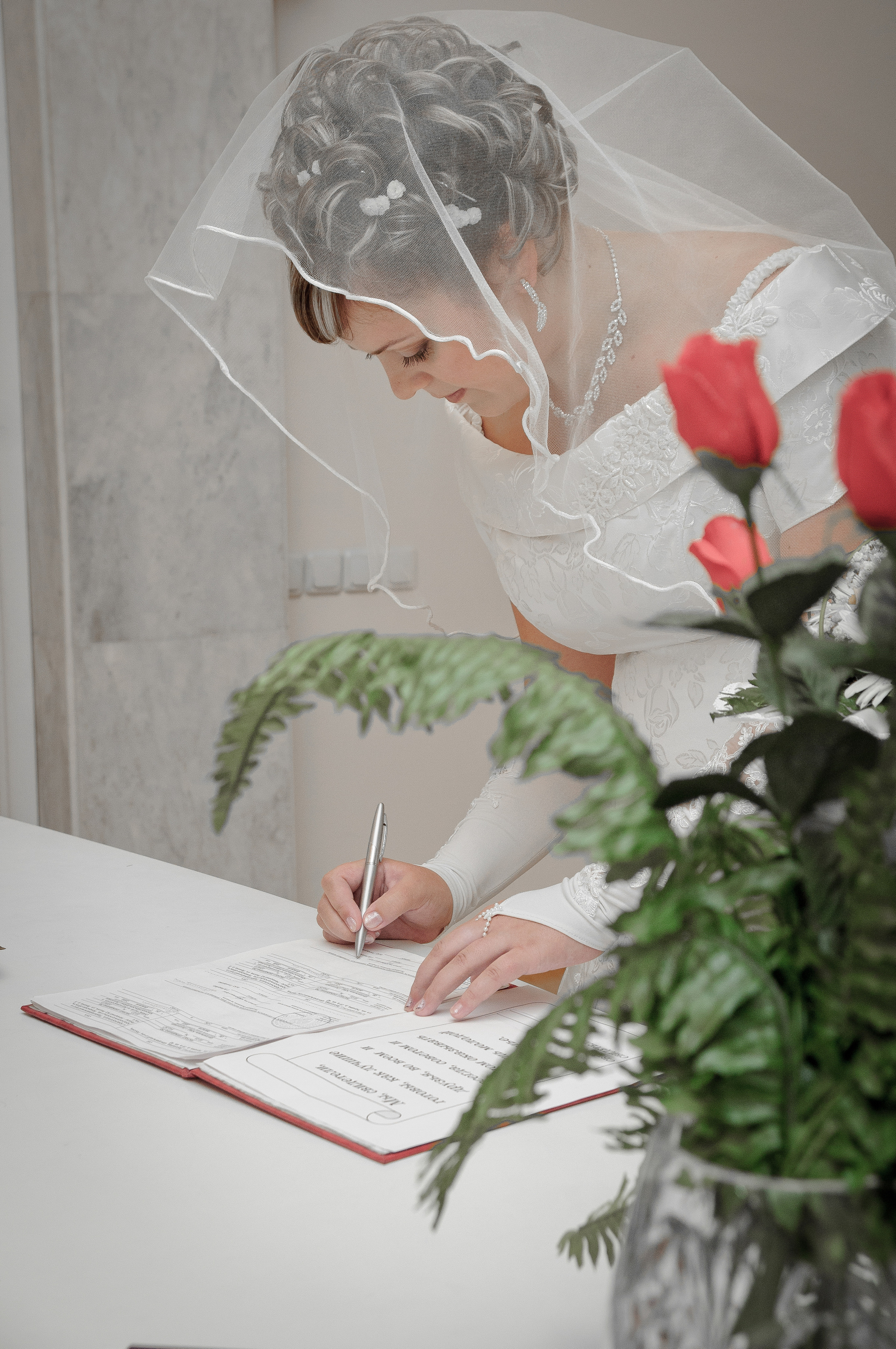 Невеста ставит роспись в ЗАГСе во время бракосочетания