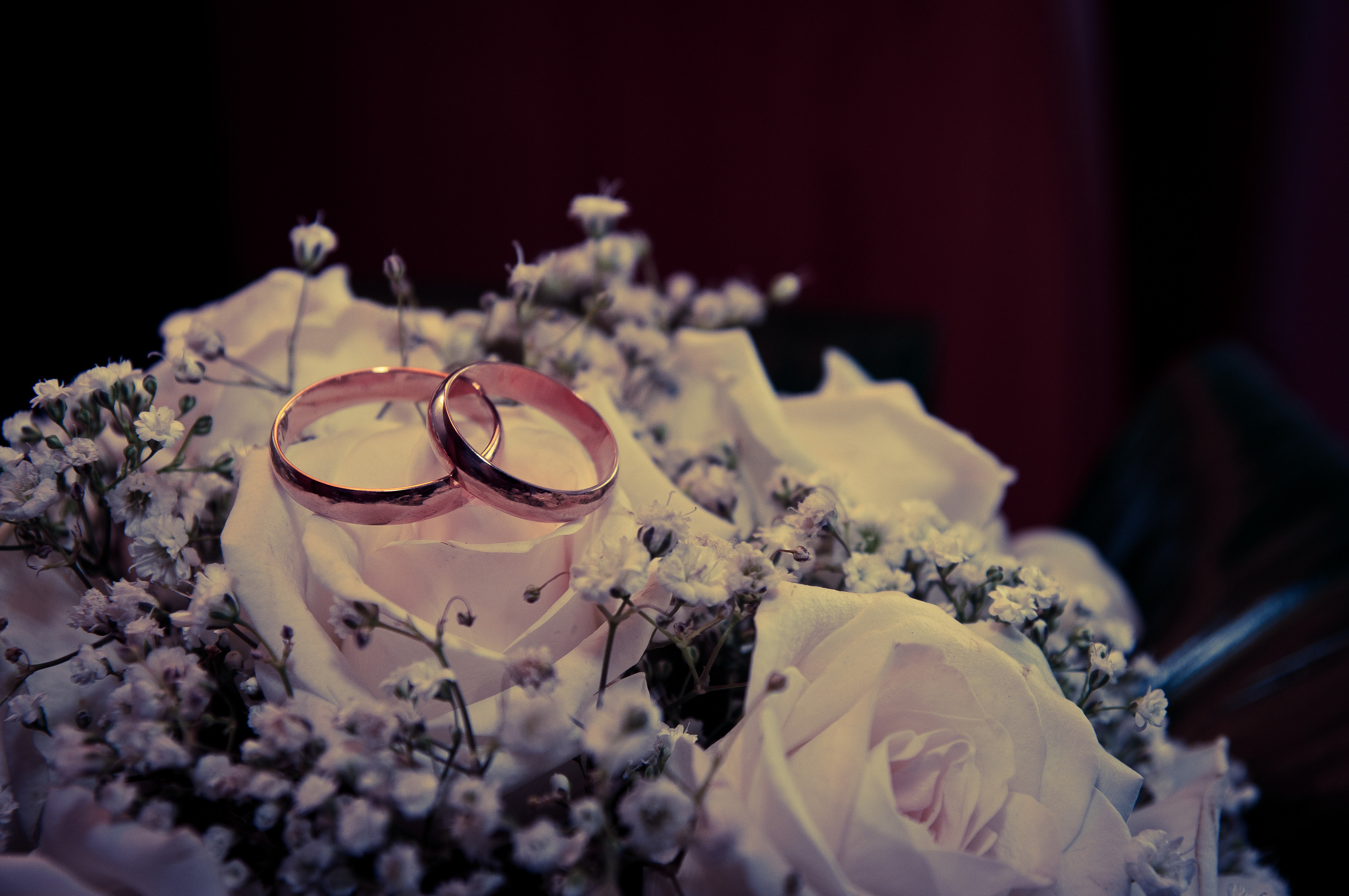 Обручальные кольца лежат на свадебном букете из бежевых роз