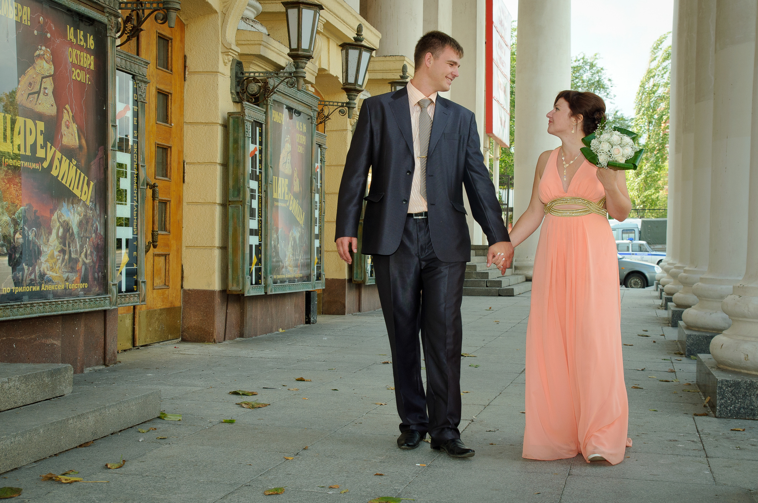 Жених и невеста идут вдоль колонн и смотрят друг на друга