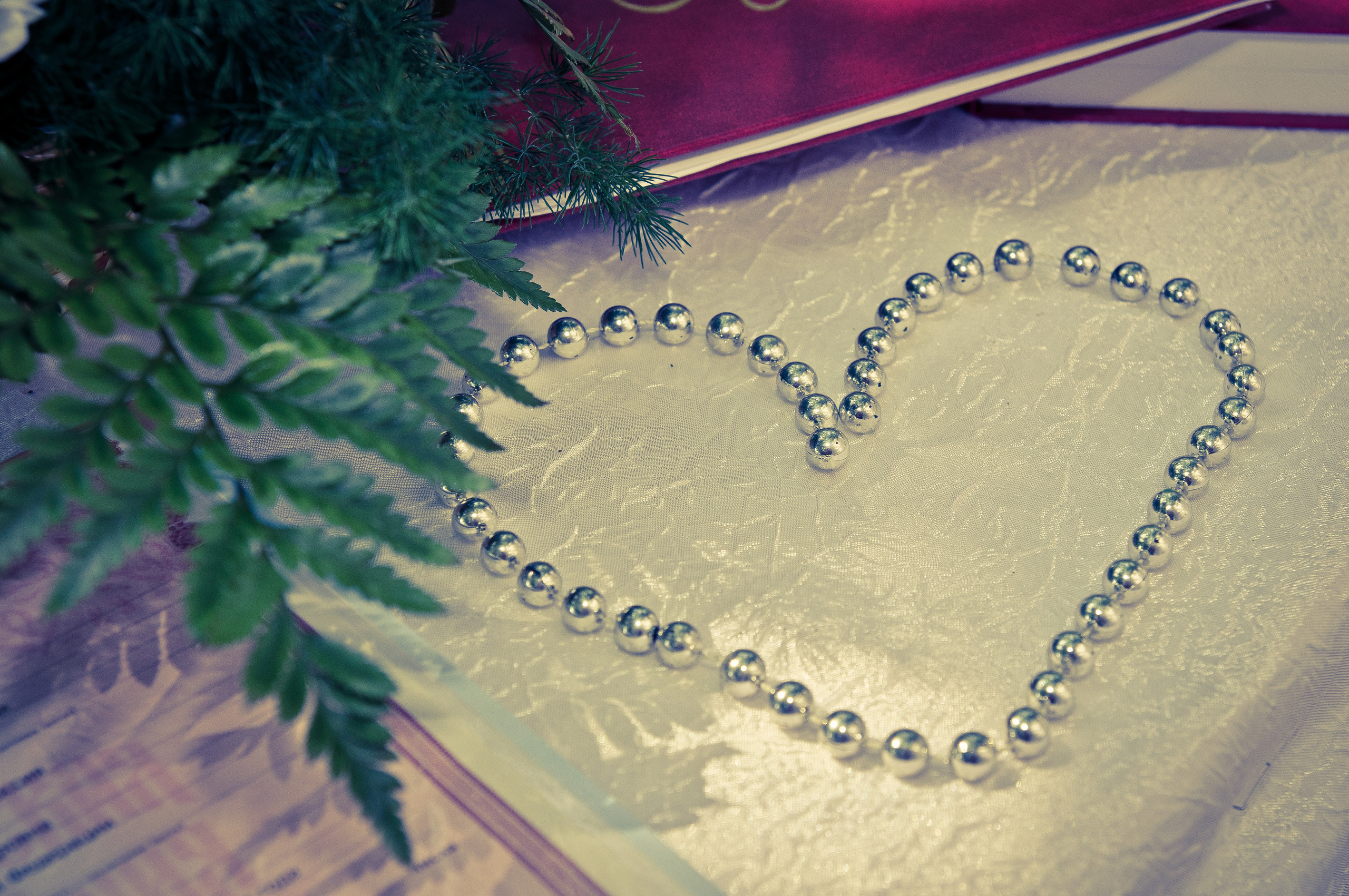 Бусы в форме сердца лежат на столе во время свадебной церемонии