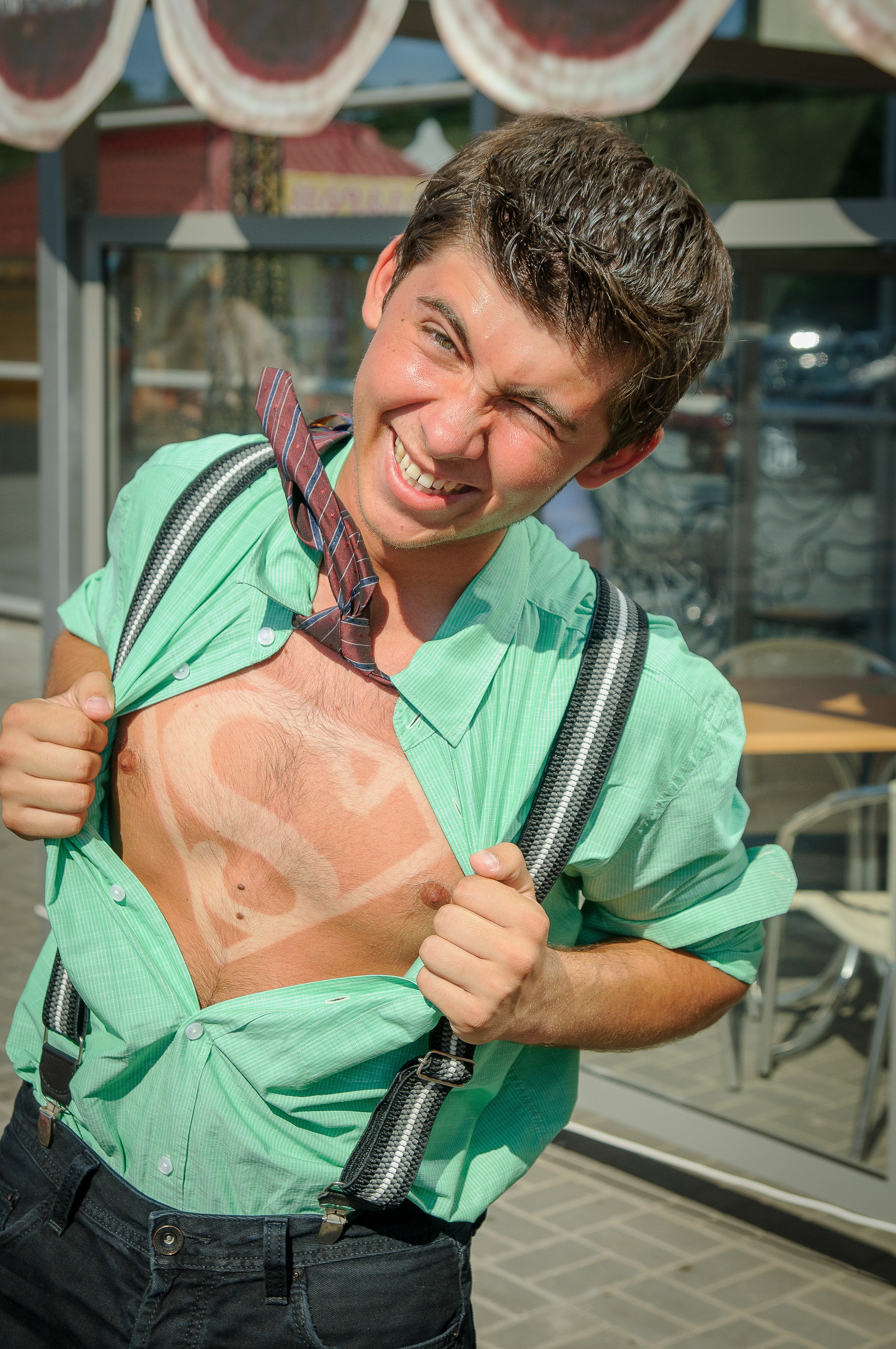 Парень разрывает на себе зелёную рубашку под которой находится знак Супермена